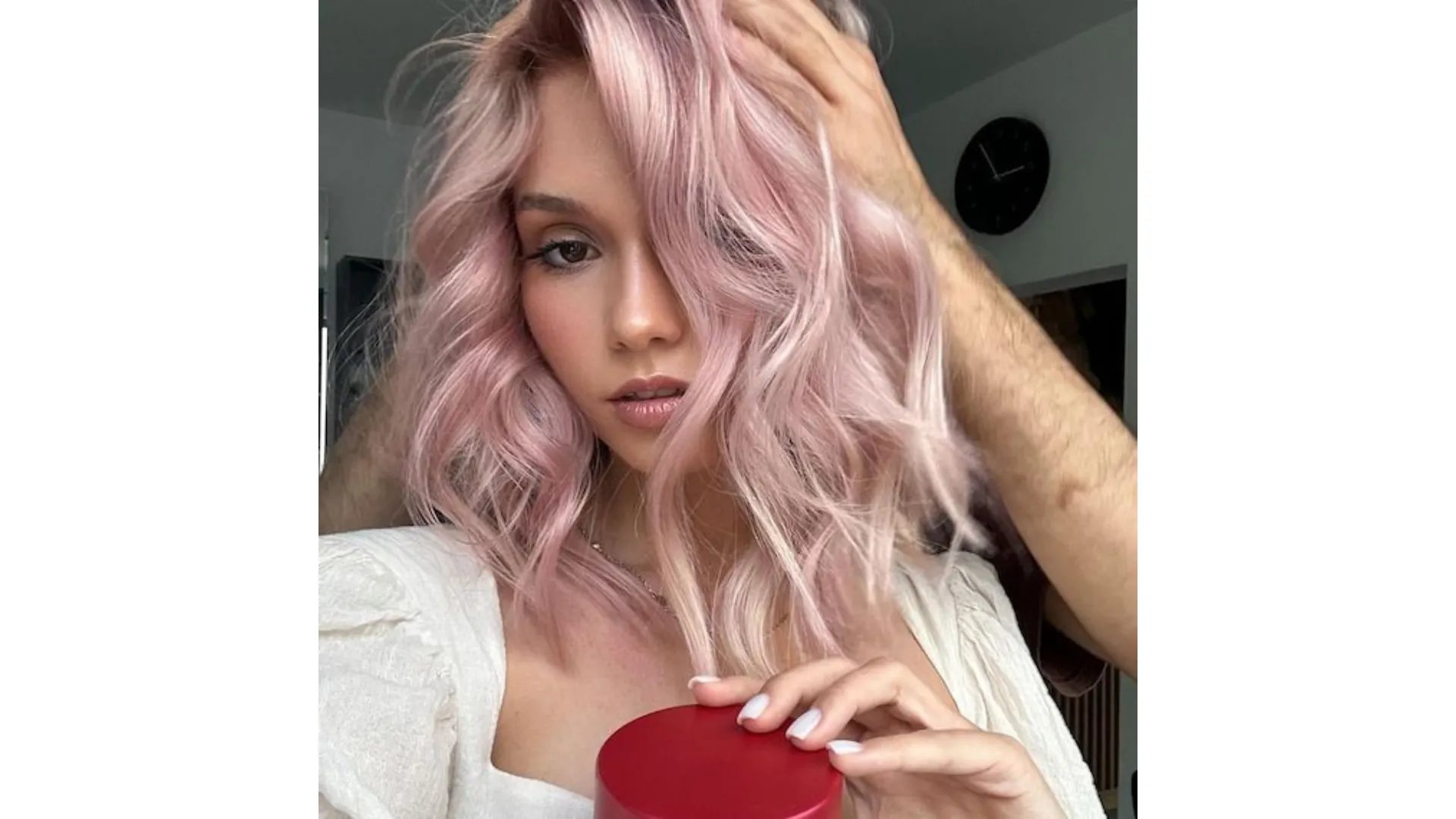 Model with loosely curled, platinum pink hair. 