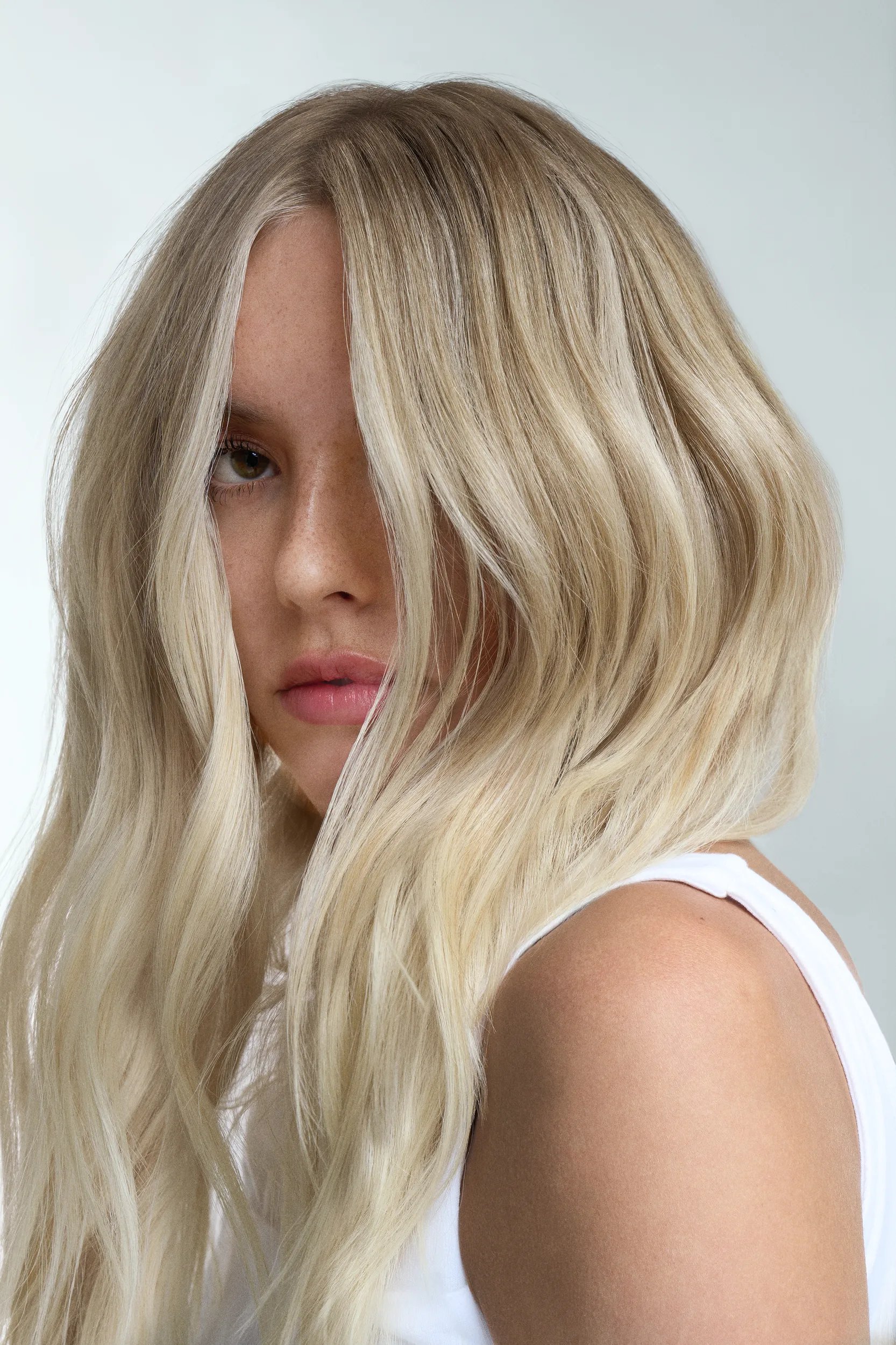Close-up of model’s icy blonde, wavy hair.