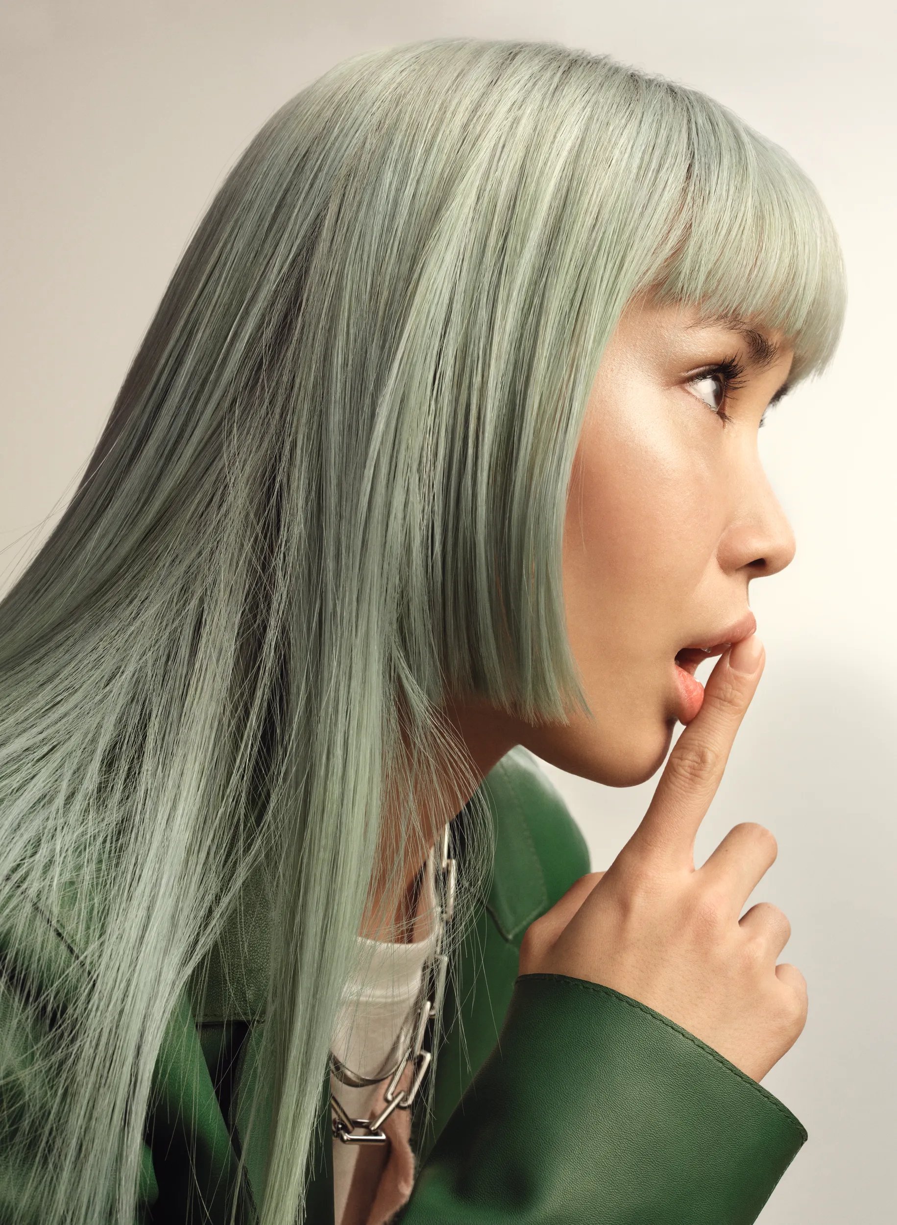 Photograph of a young female model with light green hair.