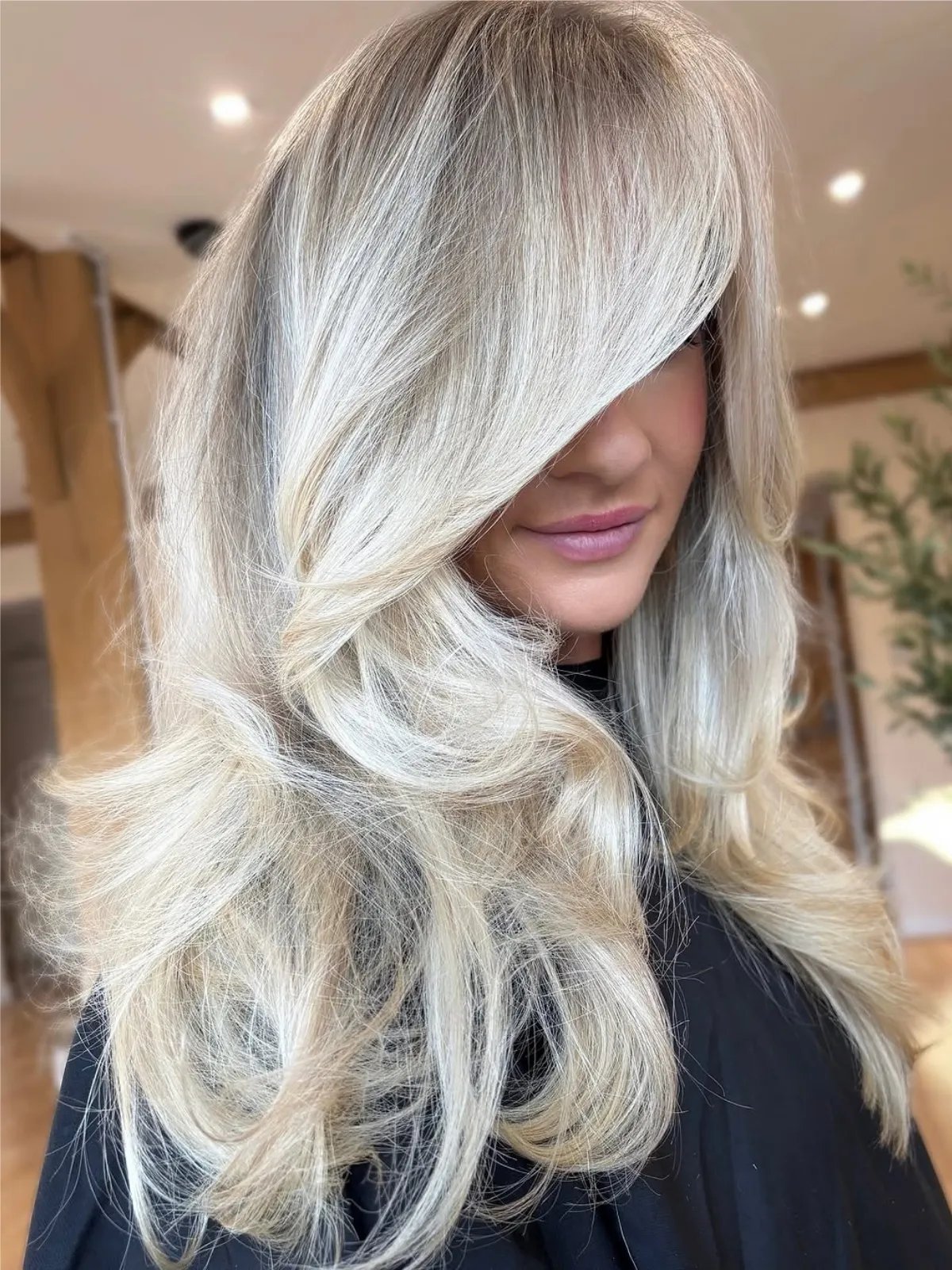 Model with a bombshell blow-dry in a multi-tonal platinum blonde shade.