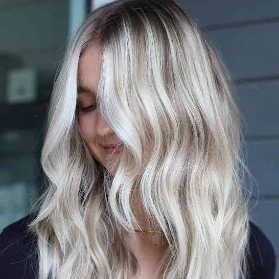 Model with type 2A wavy hair looks down. 