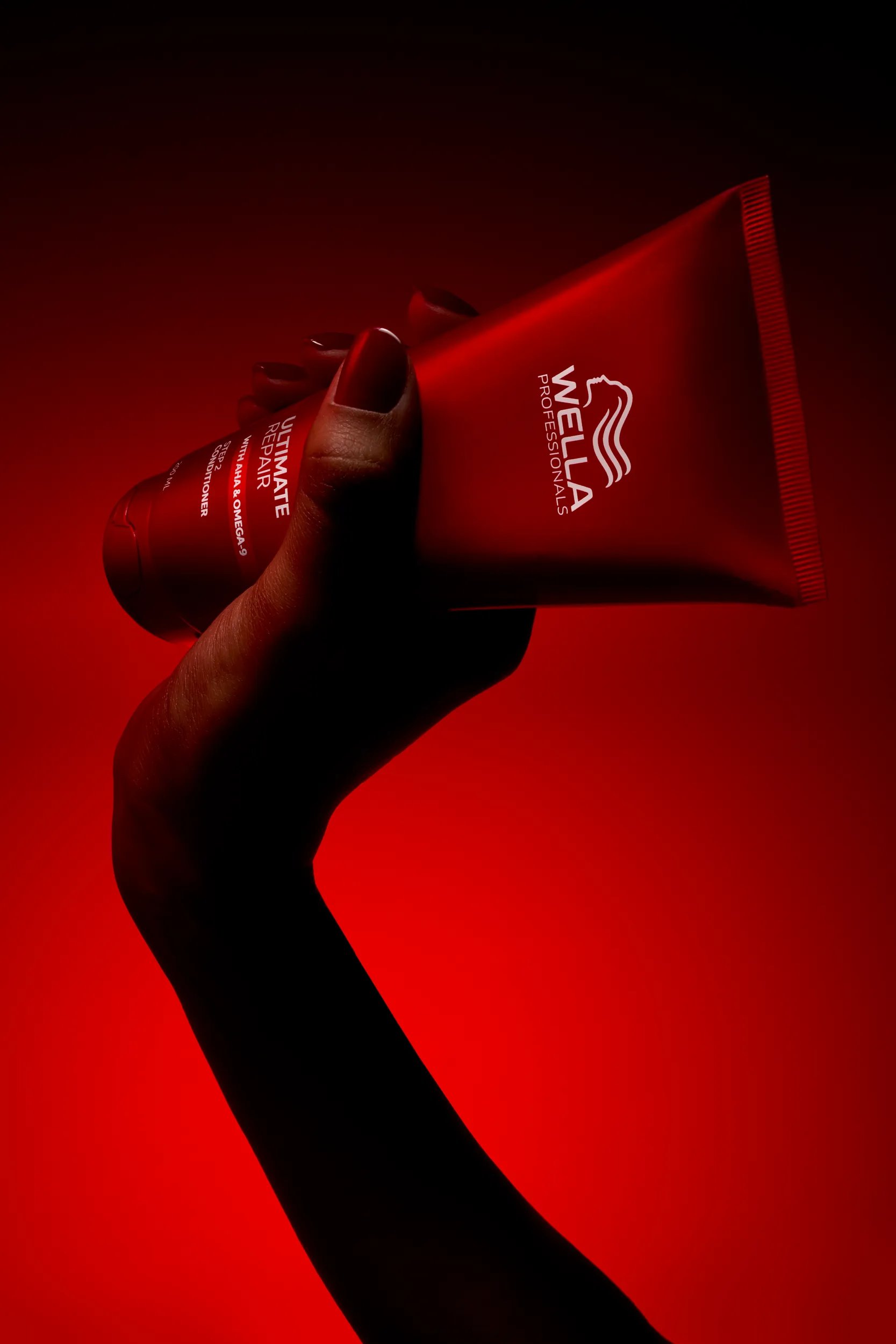 Ultimate Repair Conditioner over a red background