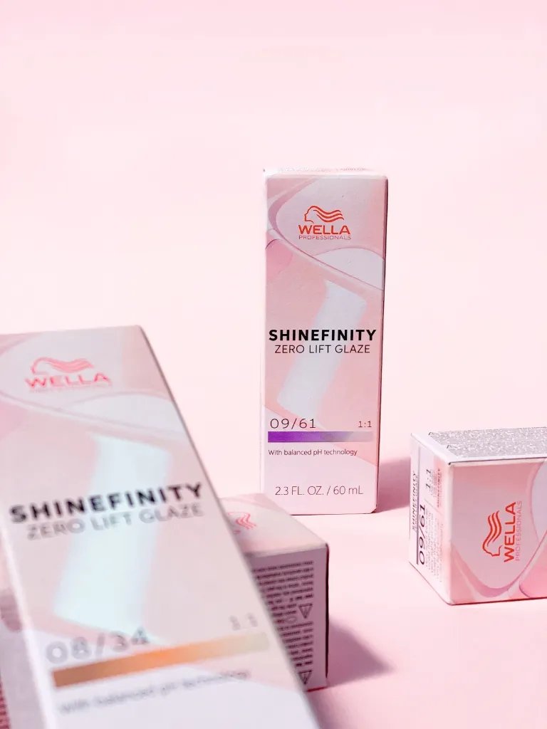 Boxes of SHINEFINITY Color Glaze on a pink background.
