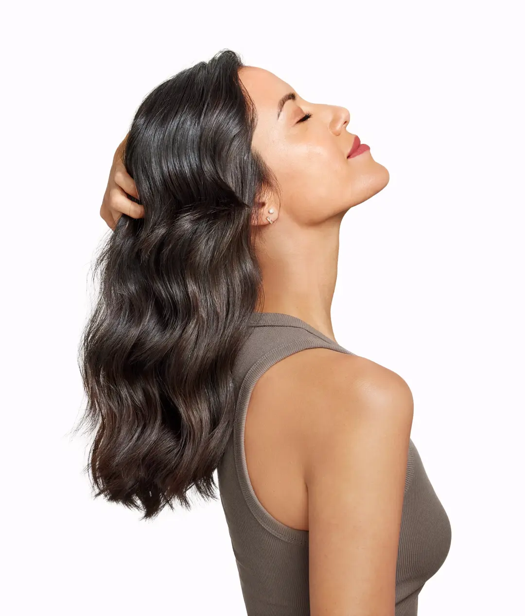 side profile of brunette woman with head leaning back and grabbing her hair