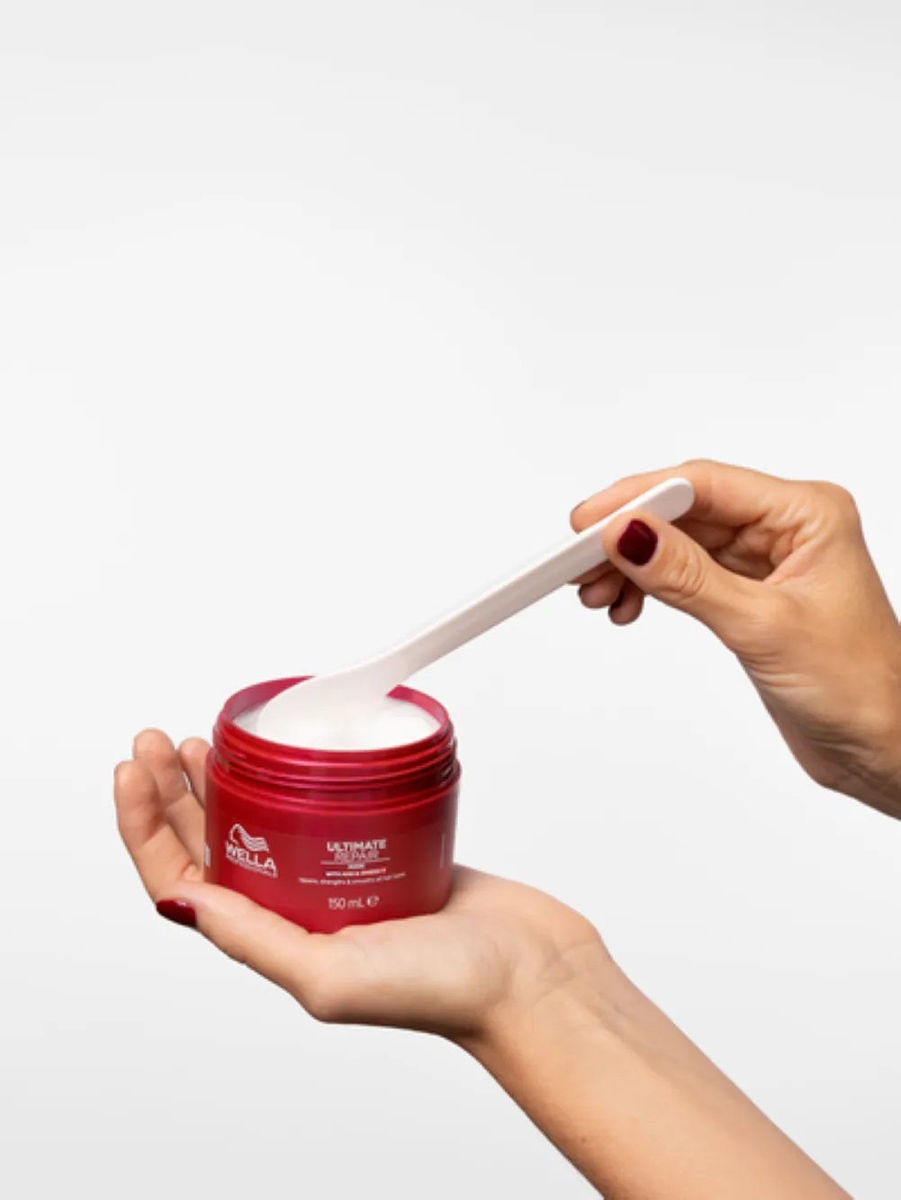 Hair mask product being prepared for application during a professional hair care routine.