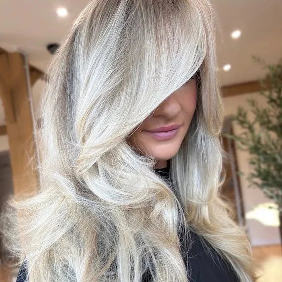 Model with rooted platinum blonde hair.