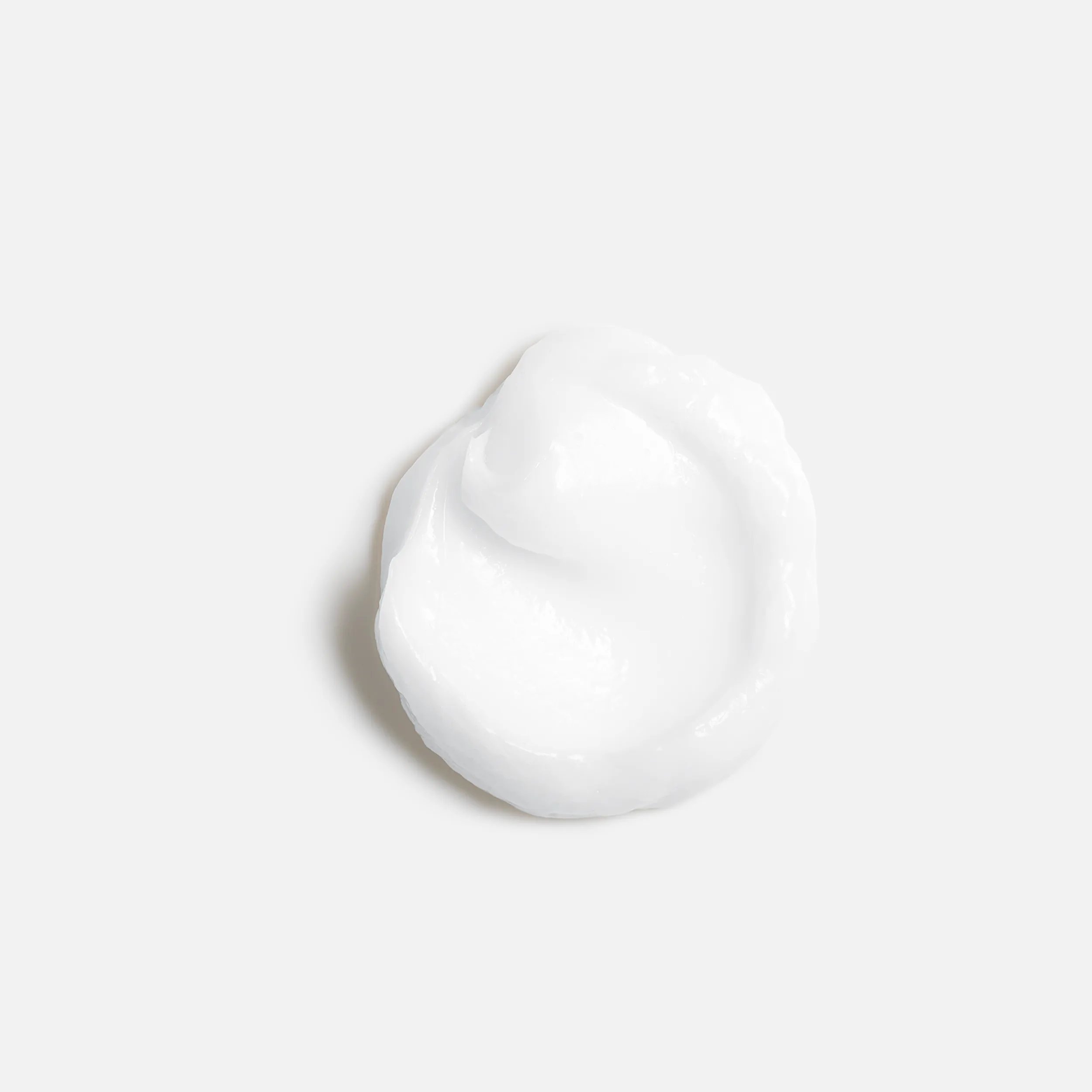 A dollop of smooth white cream on a white background.