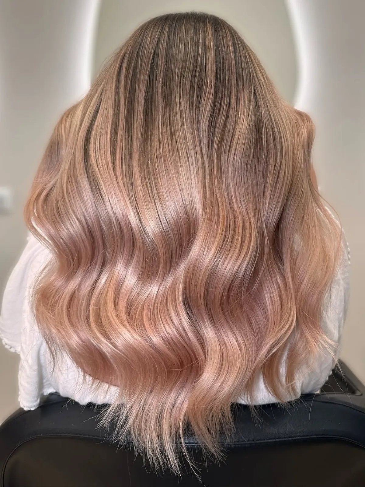 Model with rosé champagne blonde hair, featuring subtle hints of pink.