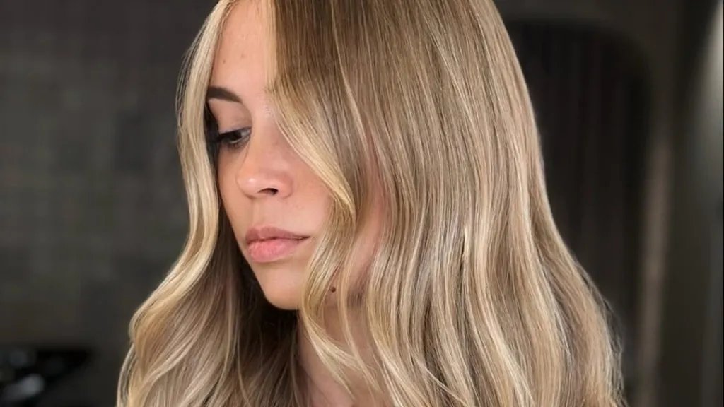 Model with long, loosely tousled, neutral blonde hair featuring beautifully blended highlights.