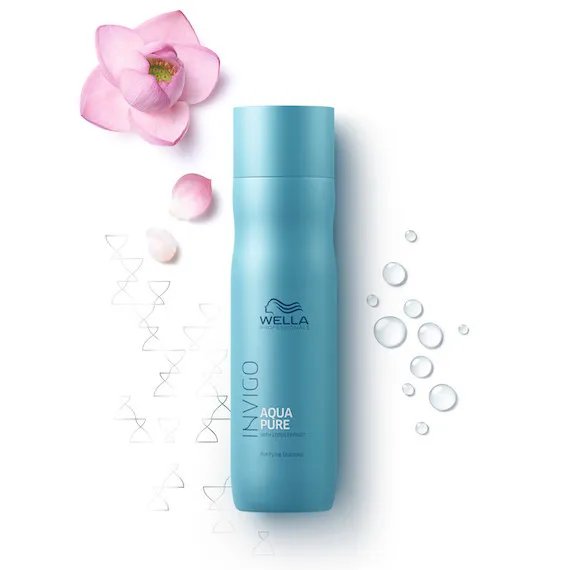 Bottle of INVIGO Aqua Pure Purifying Shampoo next to a lotus flower.