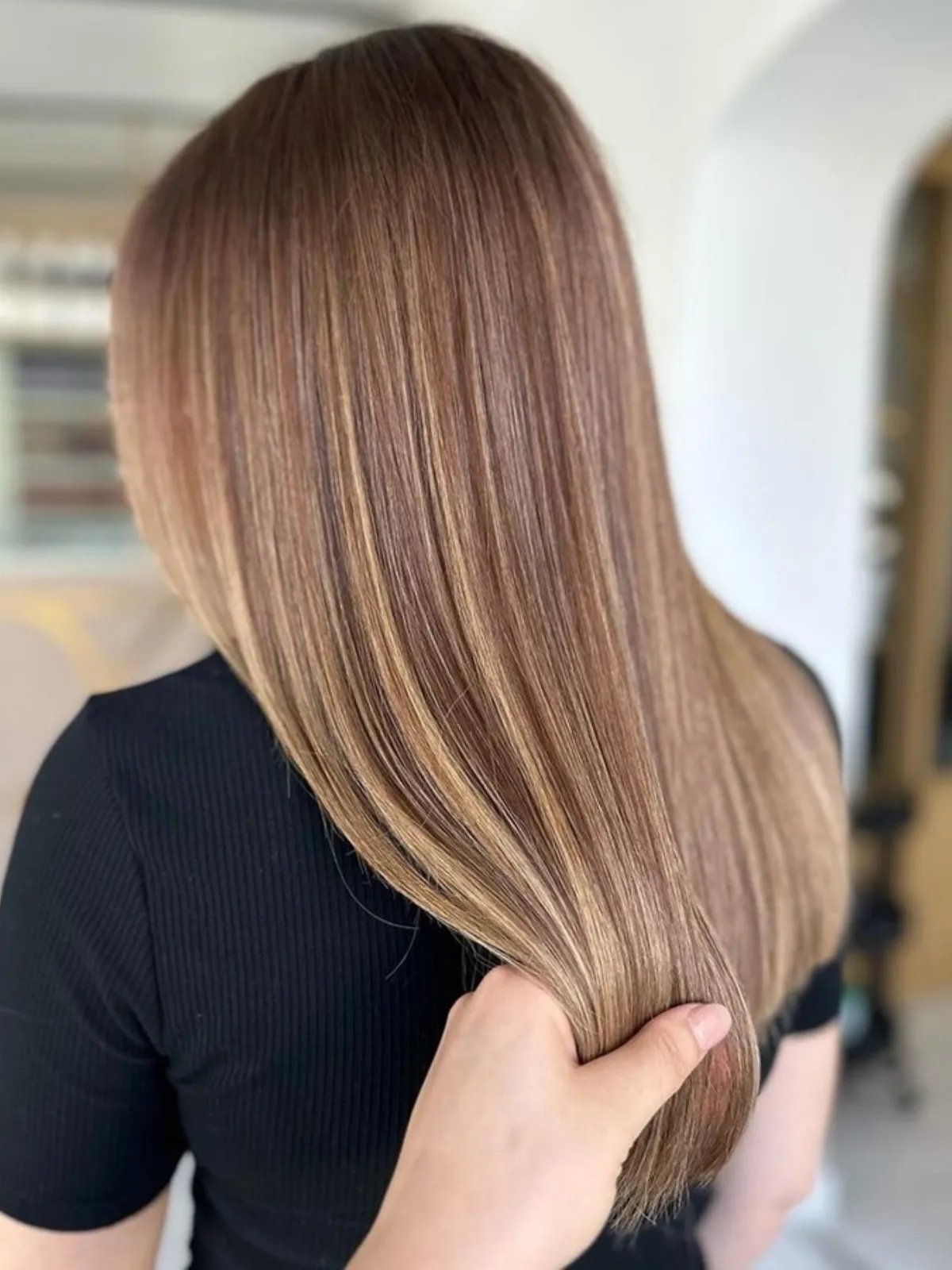 Model with long, straight, light brown hair featuring expensive-looking highlights.
