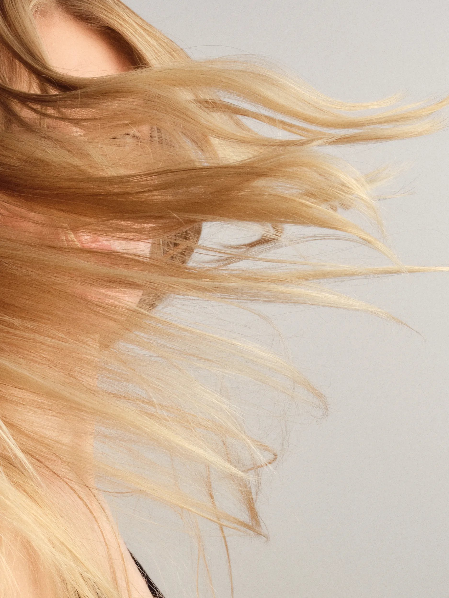 Blonde hair being tossed in the air, showing movement and texture.