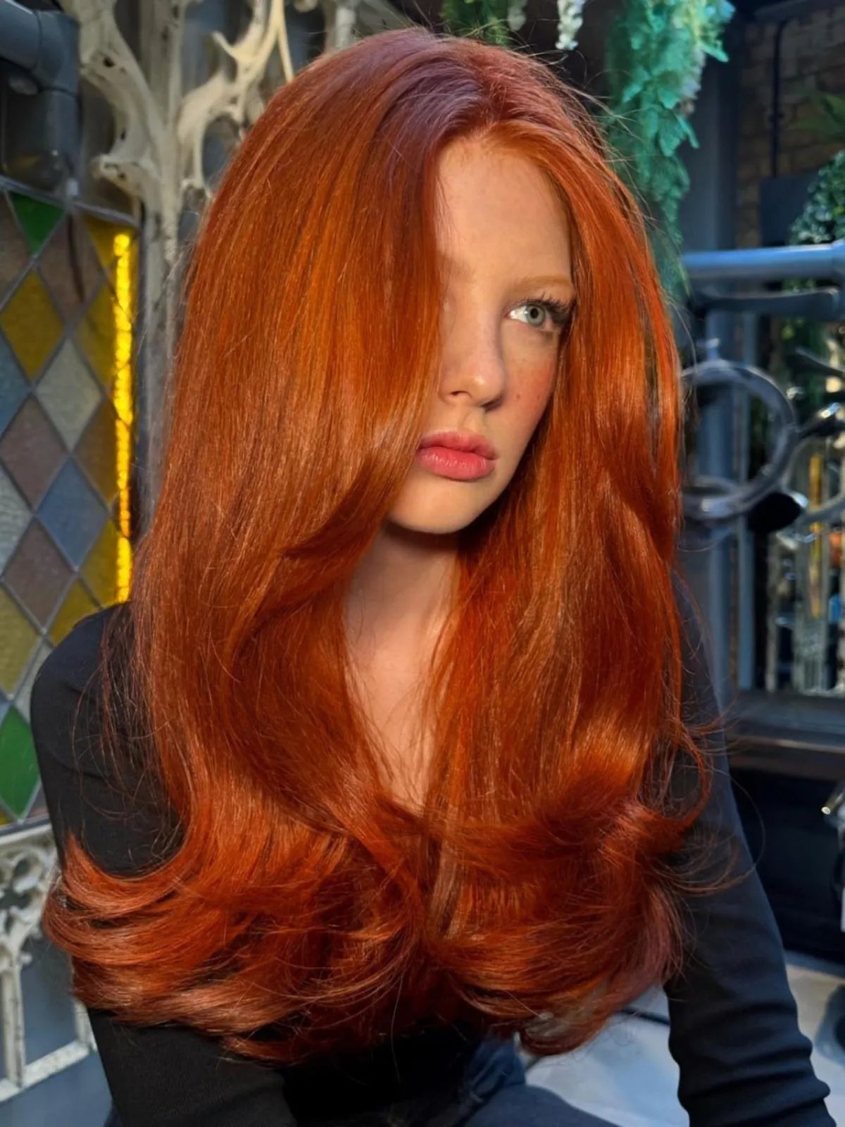 Model with bright orange-red hair styled in a bouncy blow-dry.
