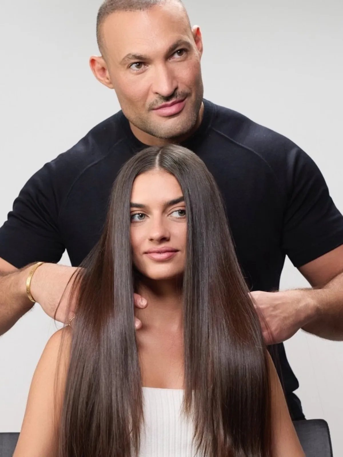 Romeu Felipe runs hands through a model’s long, smooth, glossy, brown hair.