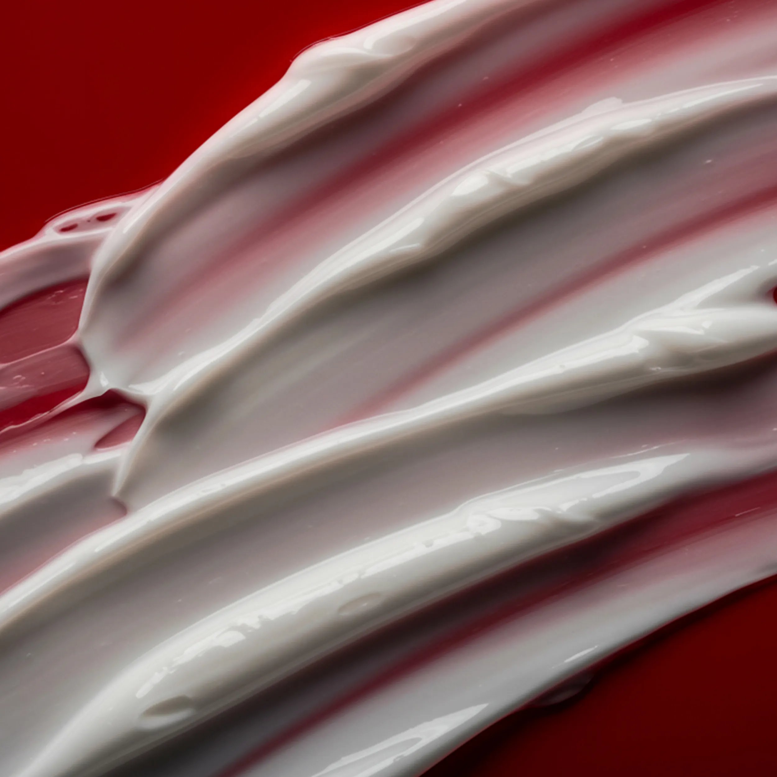 Cream smear on a red background.