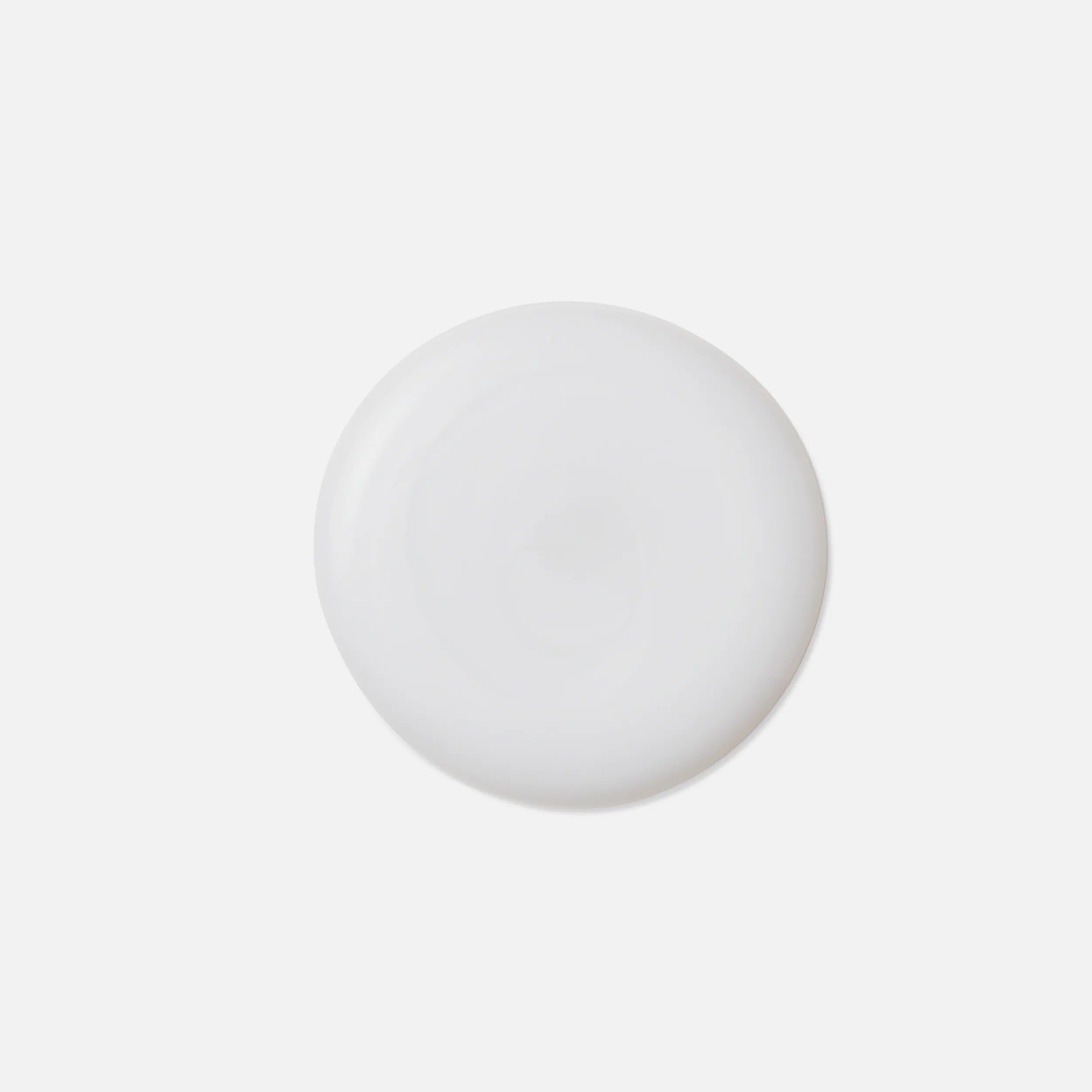 A smooth, round drop of white liquid.