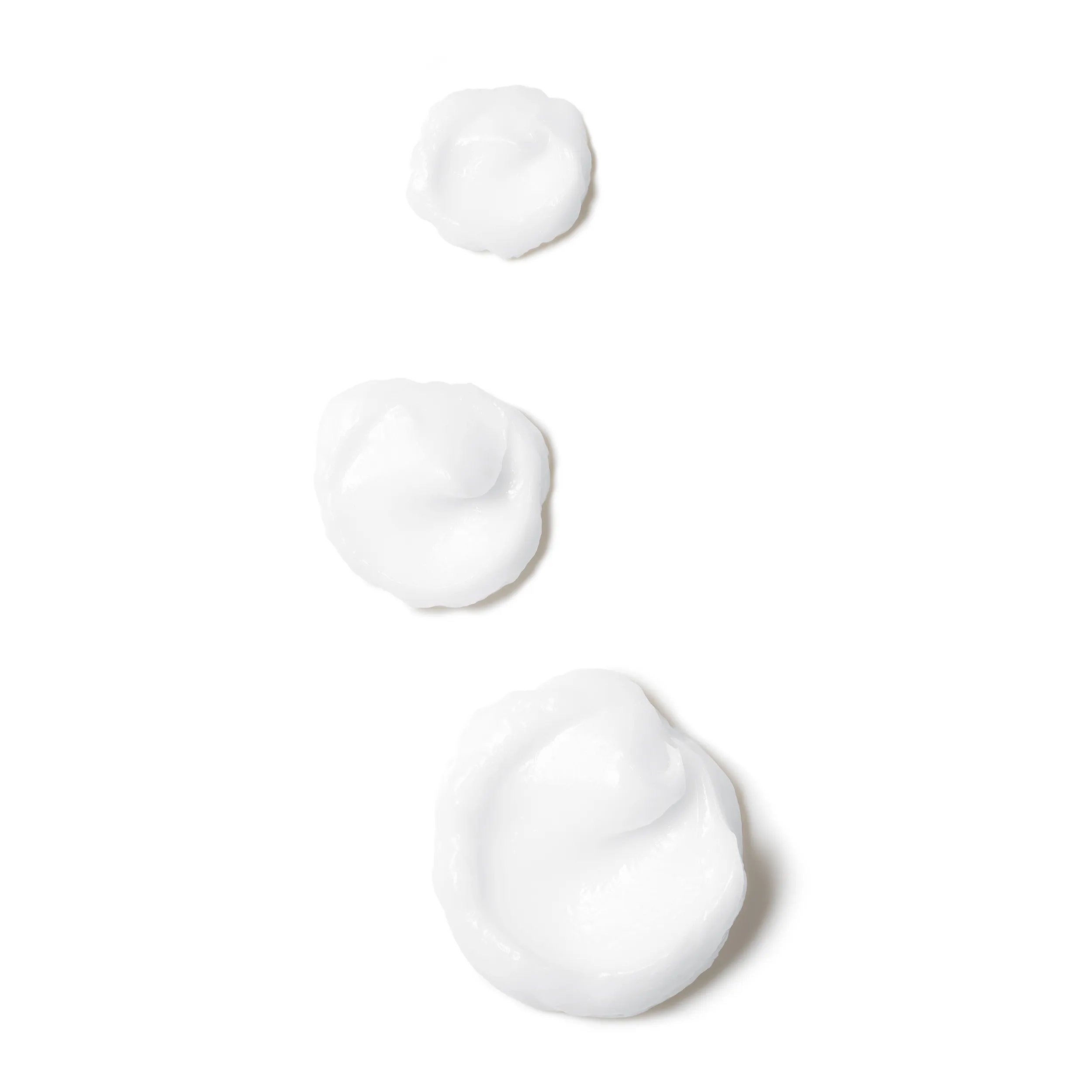 A small dollop of white cream against a plain white background.