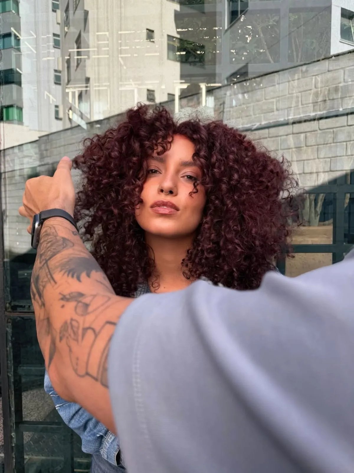 Model with full, voluminous, cherry cola red curls.