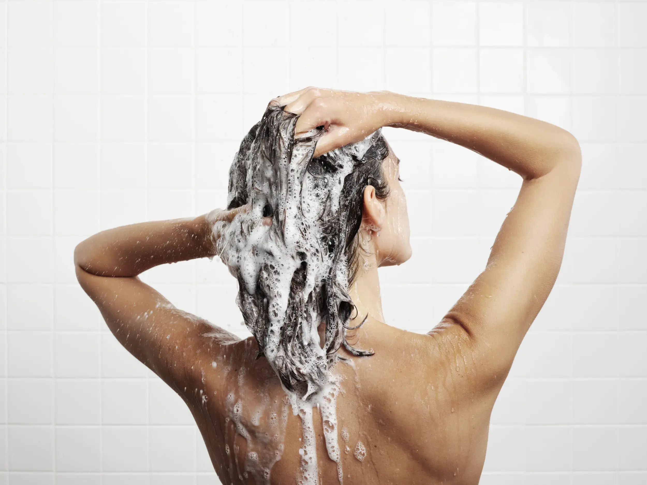 brunette woman shampooing her hair