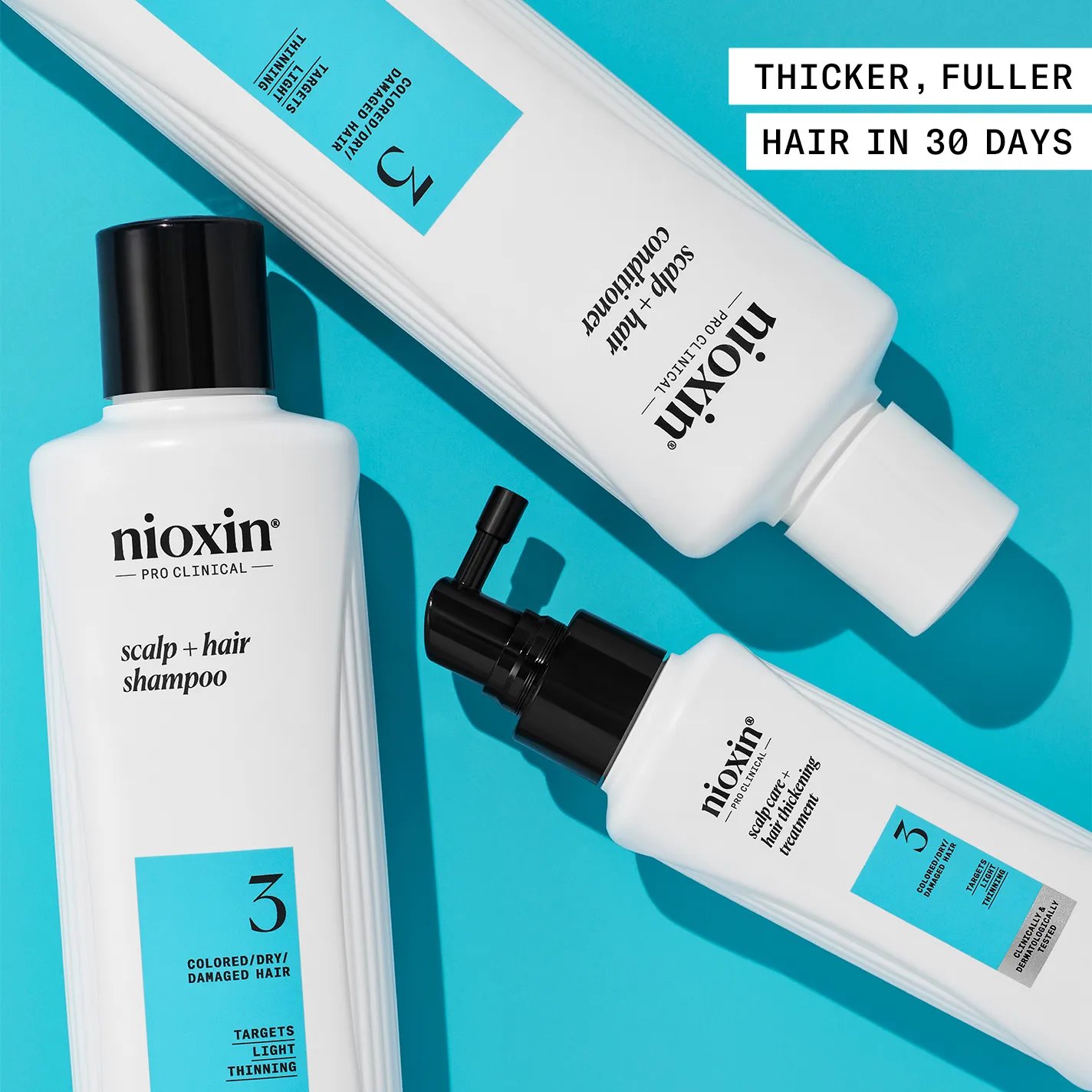 Nioxin system 3 shampoo, conditioner and hair thickening treatment against blue background