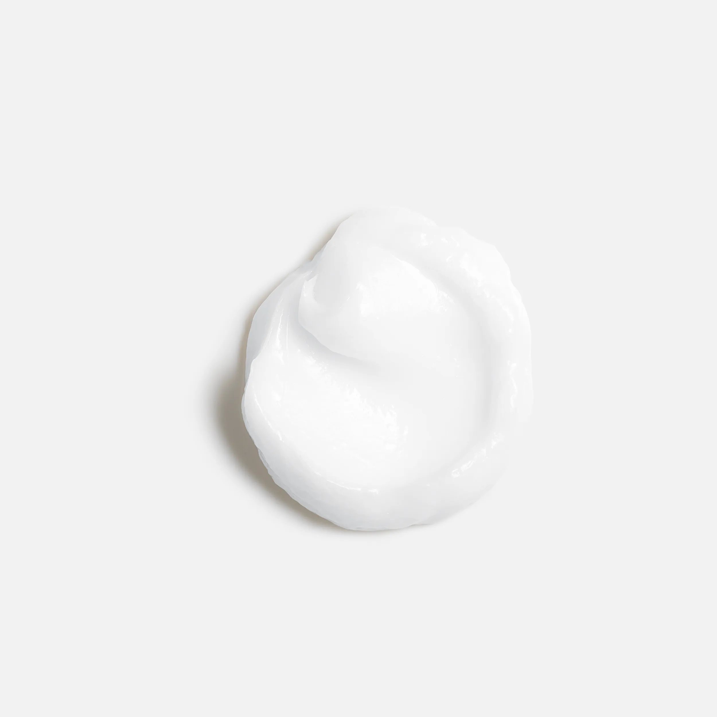 A small dollop of white cream against a plain white background.