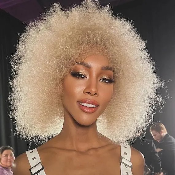 Model with golden platinum blonde curly hair.