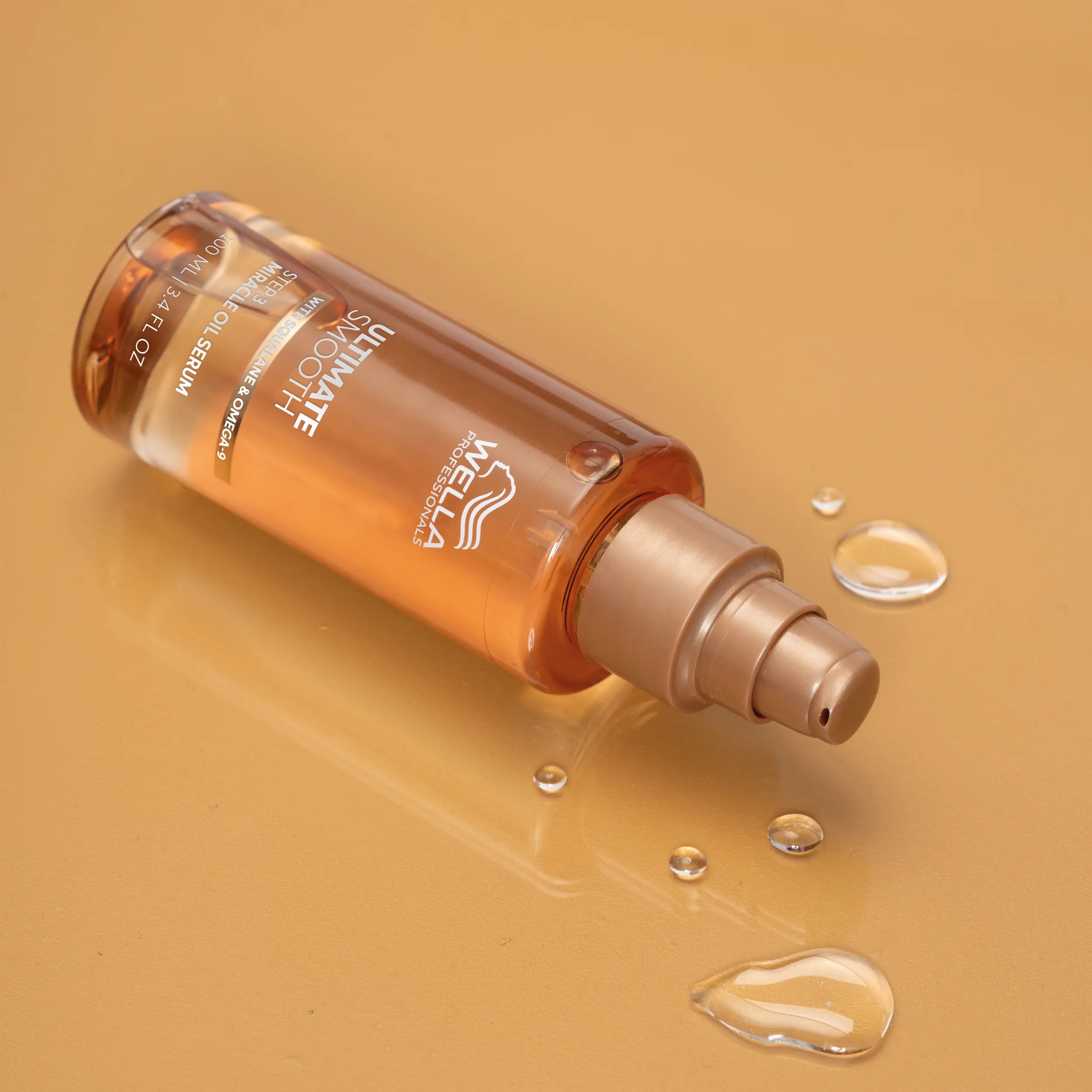 A bottle of ULTIMATE SMOOTH Miracle Oil Serum on a golden surface. The delicate oil is dermatologically tested, suitable for colored hair and free of animal-derived ingredients.