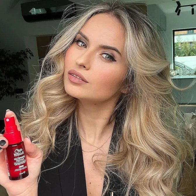 Model holds bottle of Ultimate Repair Miracle Hair Rescue