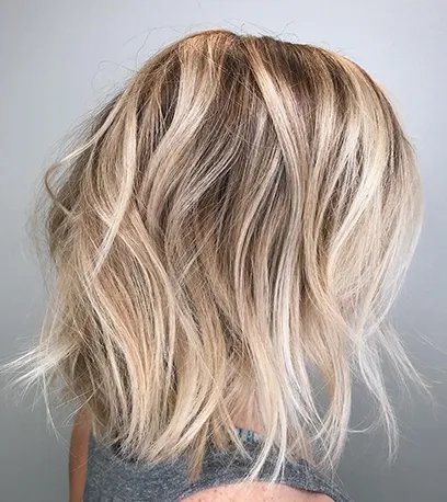 Back of woman’s head with blonde, tousled balayage bob, created using Wella Professionals.