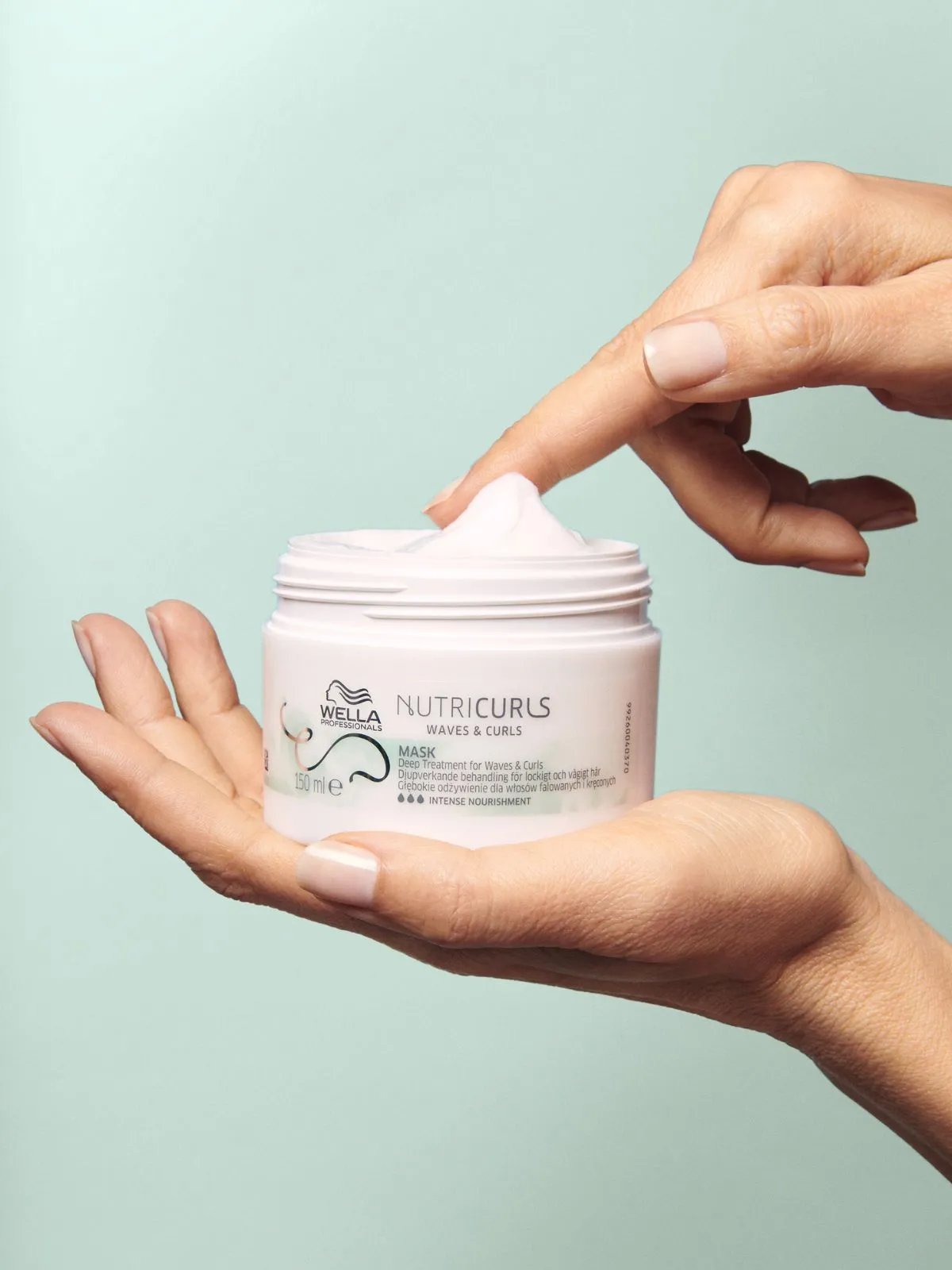 Model’s hand reaches into a jar of NutriCurls Mask.