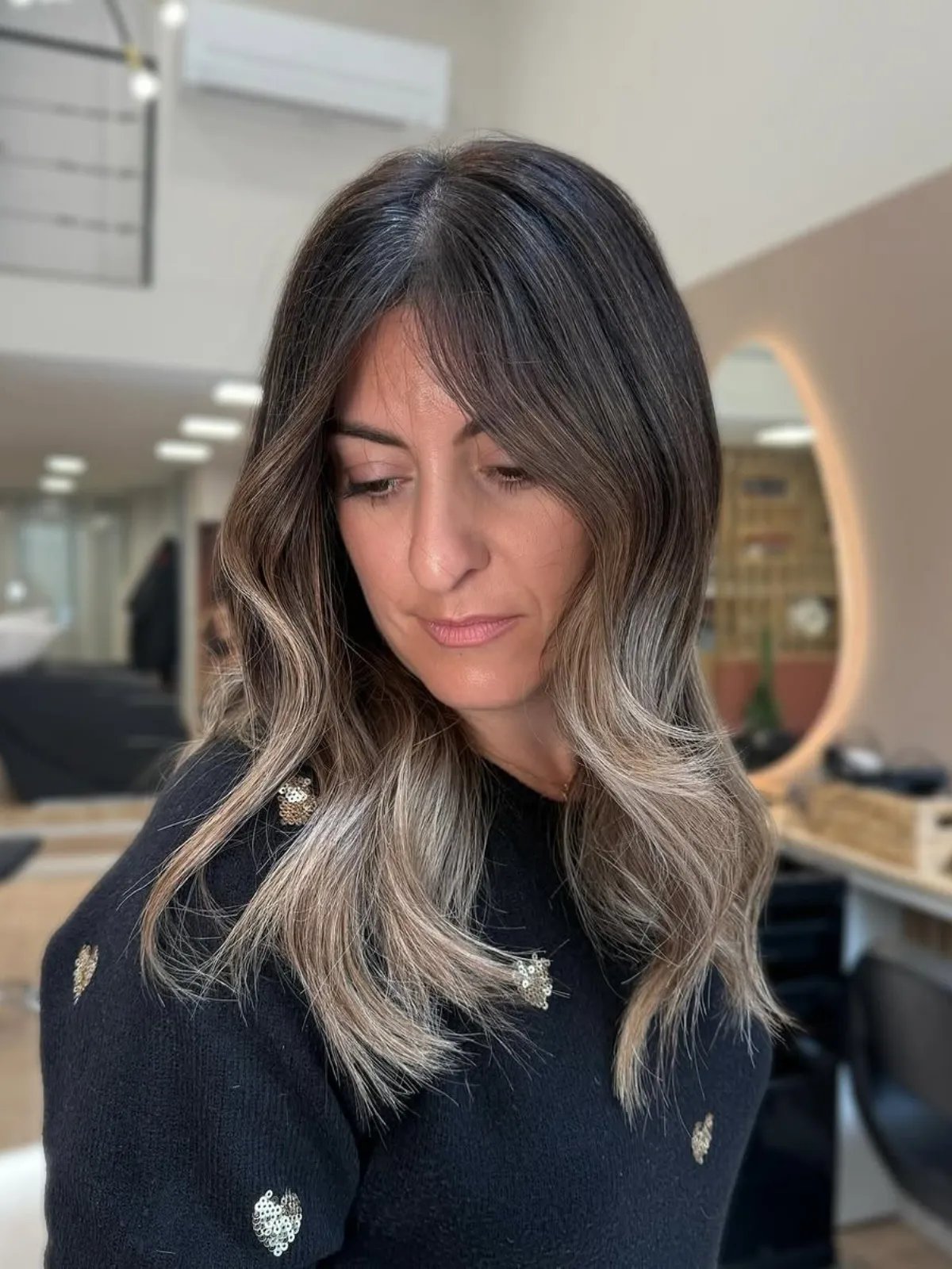 Model with dark brown hair and ash blonde face-framing highlights.