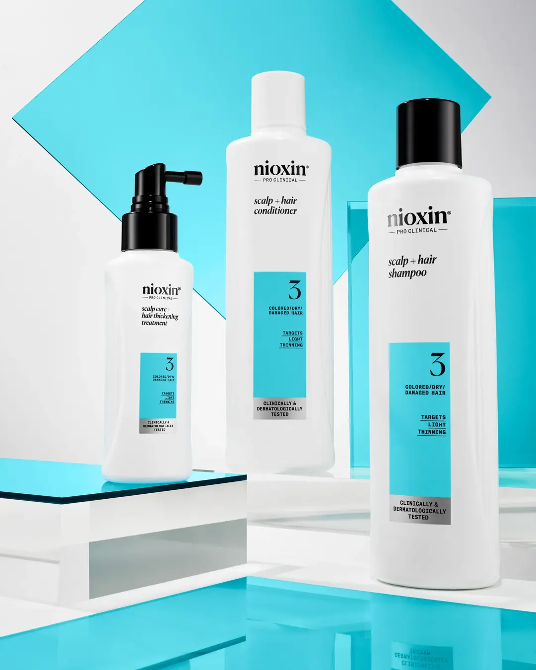 Prodotti del kit di sistema 3 di Nioxin disposti in forma triangolare con sfondo bianco e blu