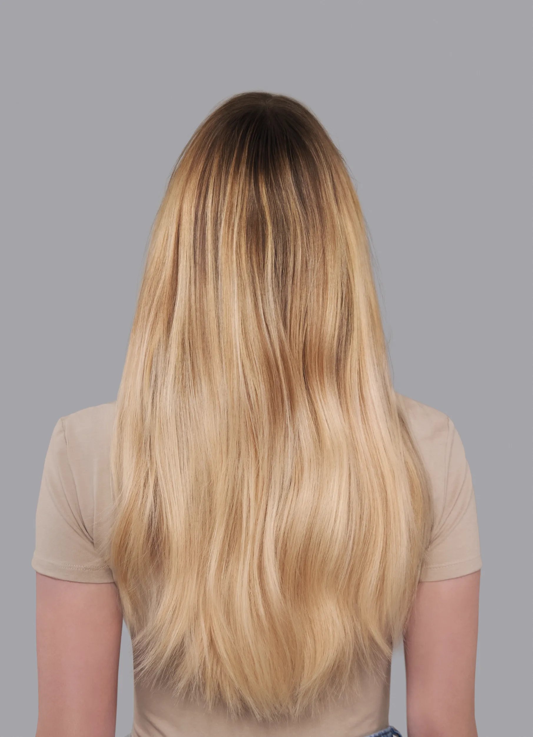 Back view of a woman with long, blonde, ombre hair.