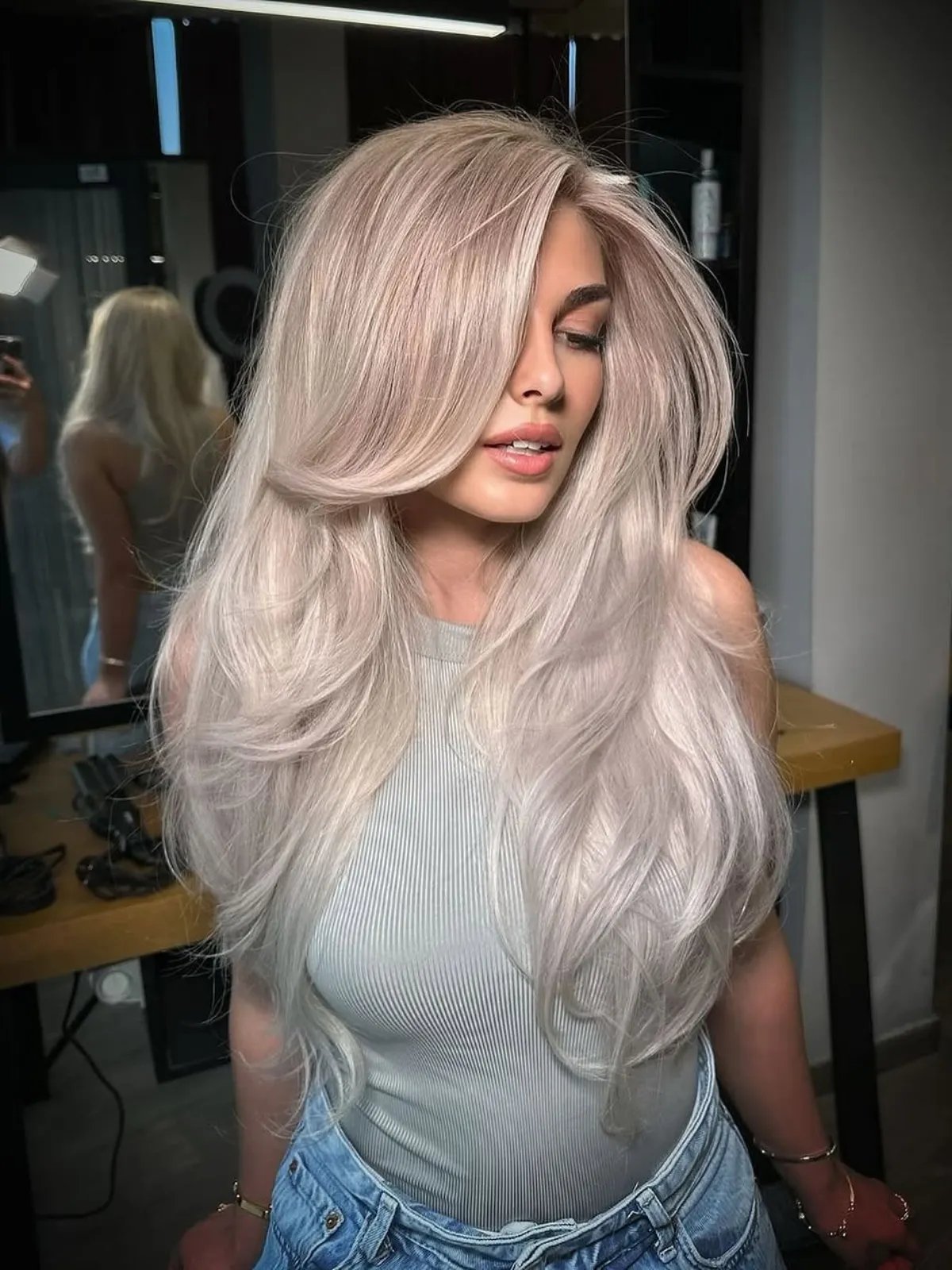 Model with long, icy platinum blonde hair styled in a bouncy blow-dry.