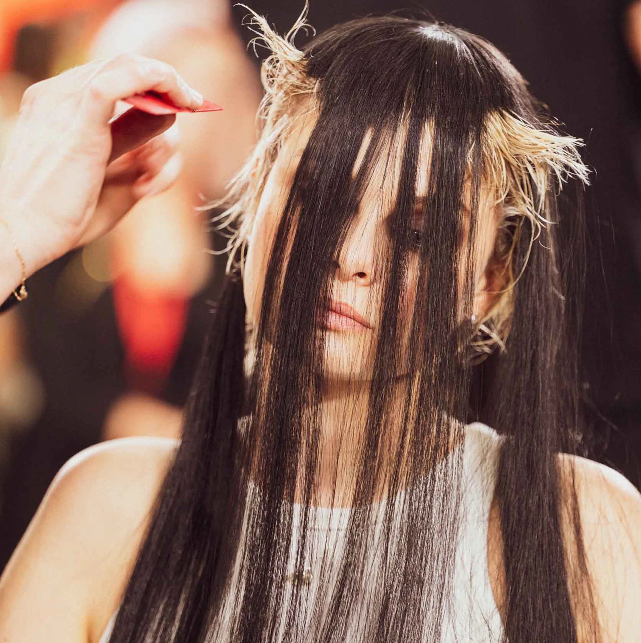 Immagine che mostra il dettaglio dell'acconciatura di una modella. I capelli rossi della modella sono raccolti con un motivo intricato. 