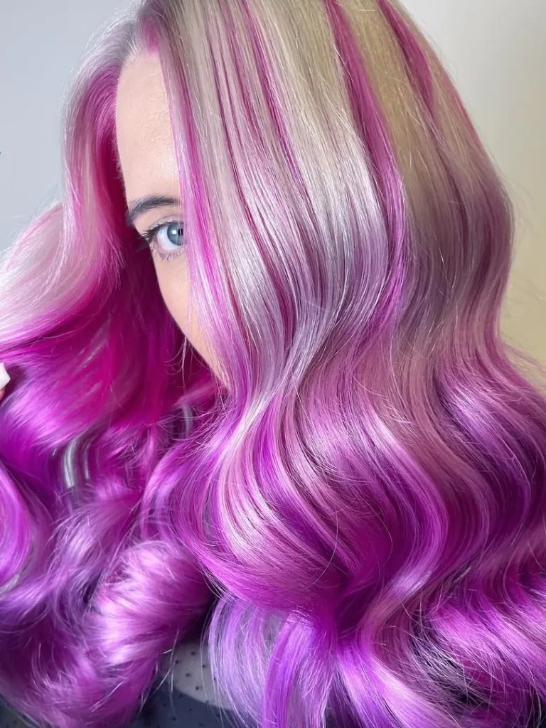 Model with platinum blonde hair featuring pink and purple highlights.