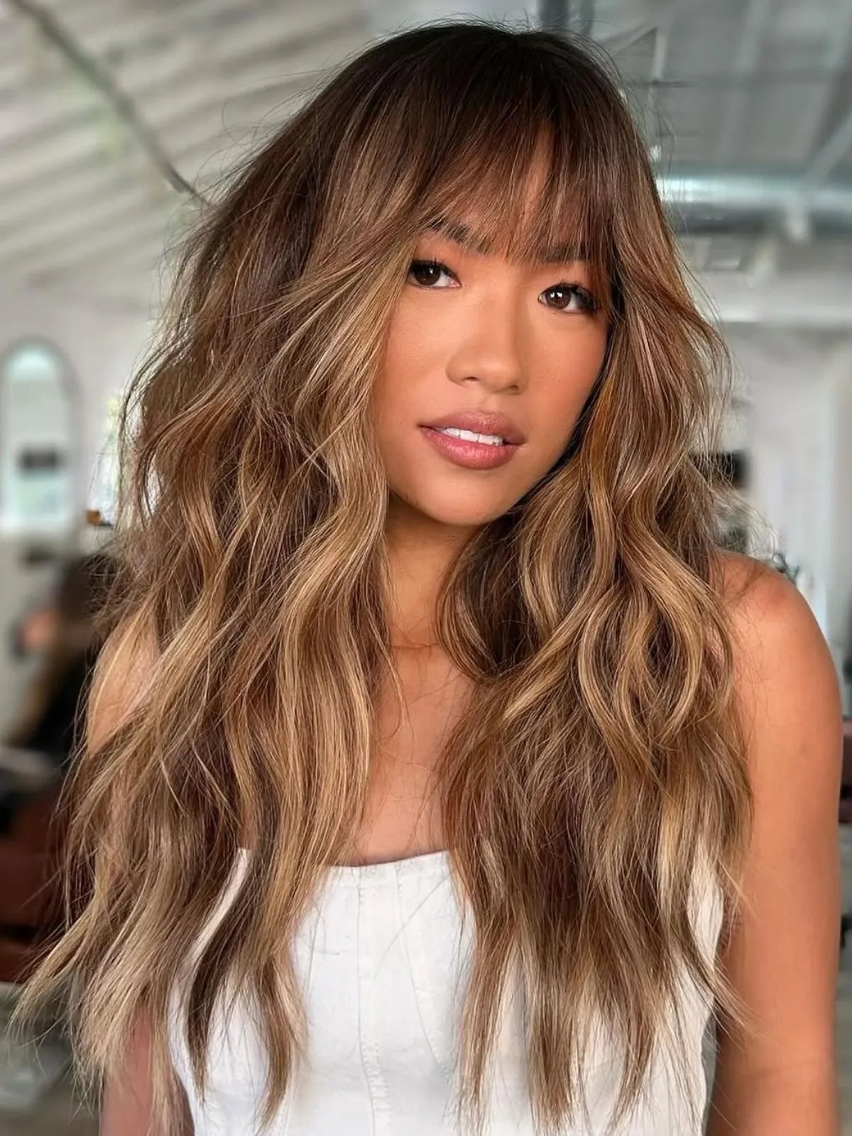 Chocolate brown hair with honey-colored highlights and sun-kissed vibrancy.