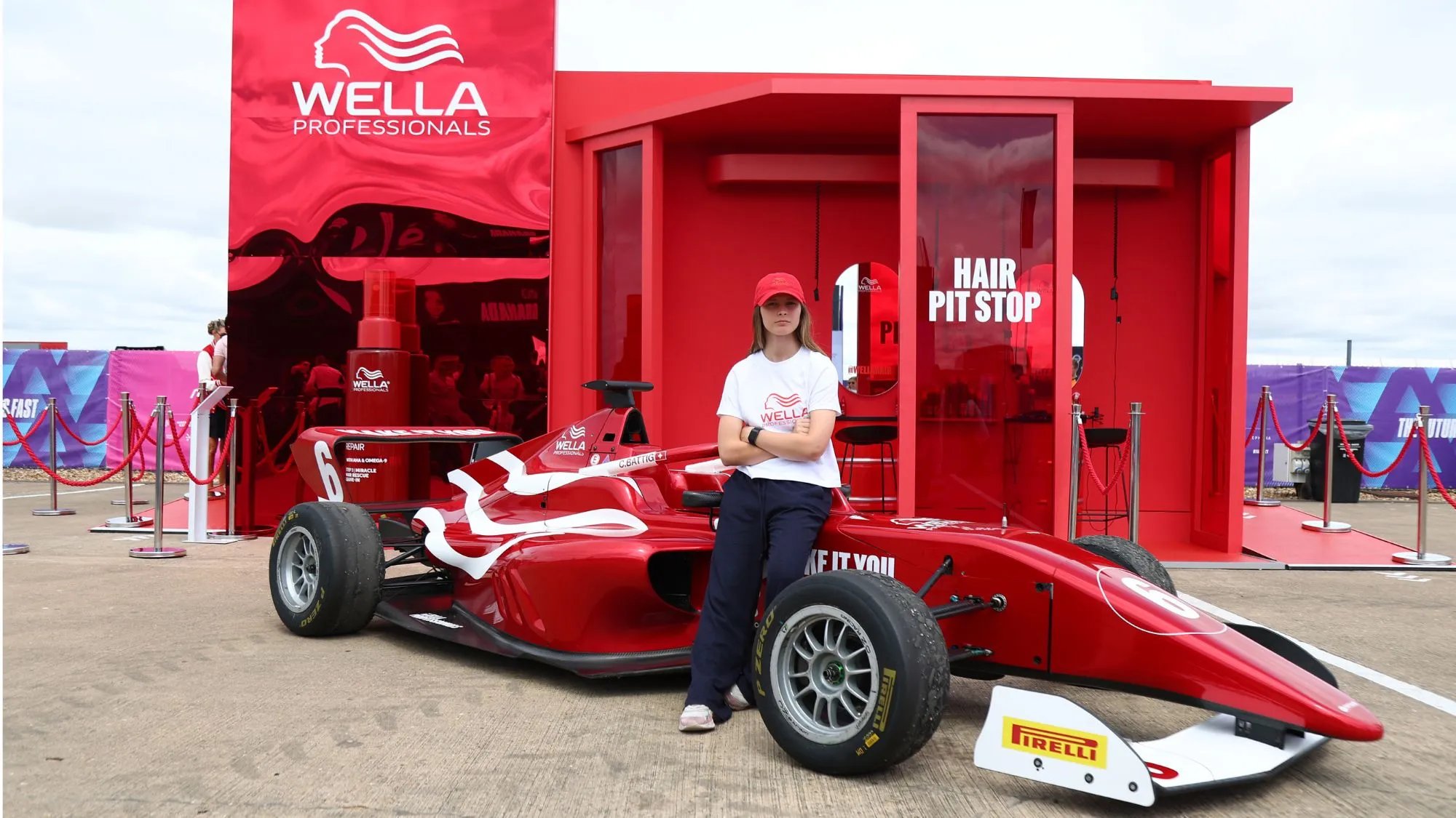 Chiara Bättig poses alongside the Wella Pop-Up and MAKE IT YOU racecar at Silverstone.