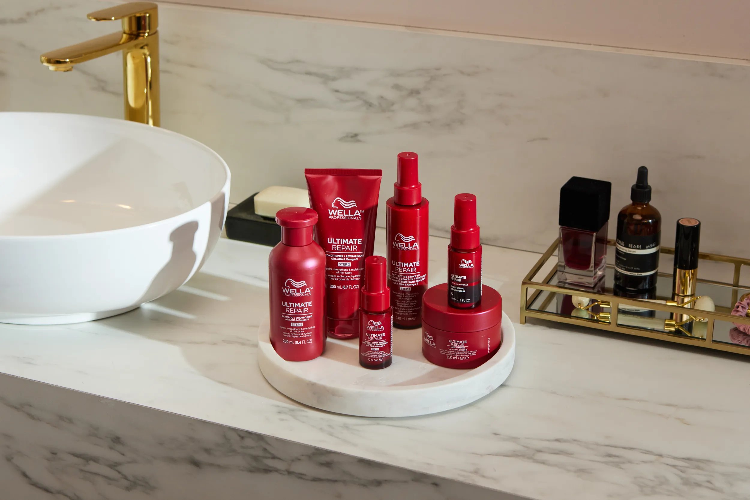 ULTIMATE REPAIR Shampoo, Conditioner, Miracle Hair Rescue, Protective Leave-In, Night Serum and Mask in a marble bathroom.