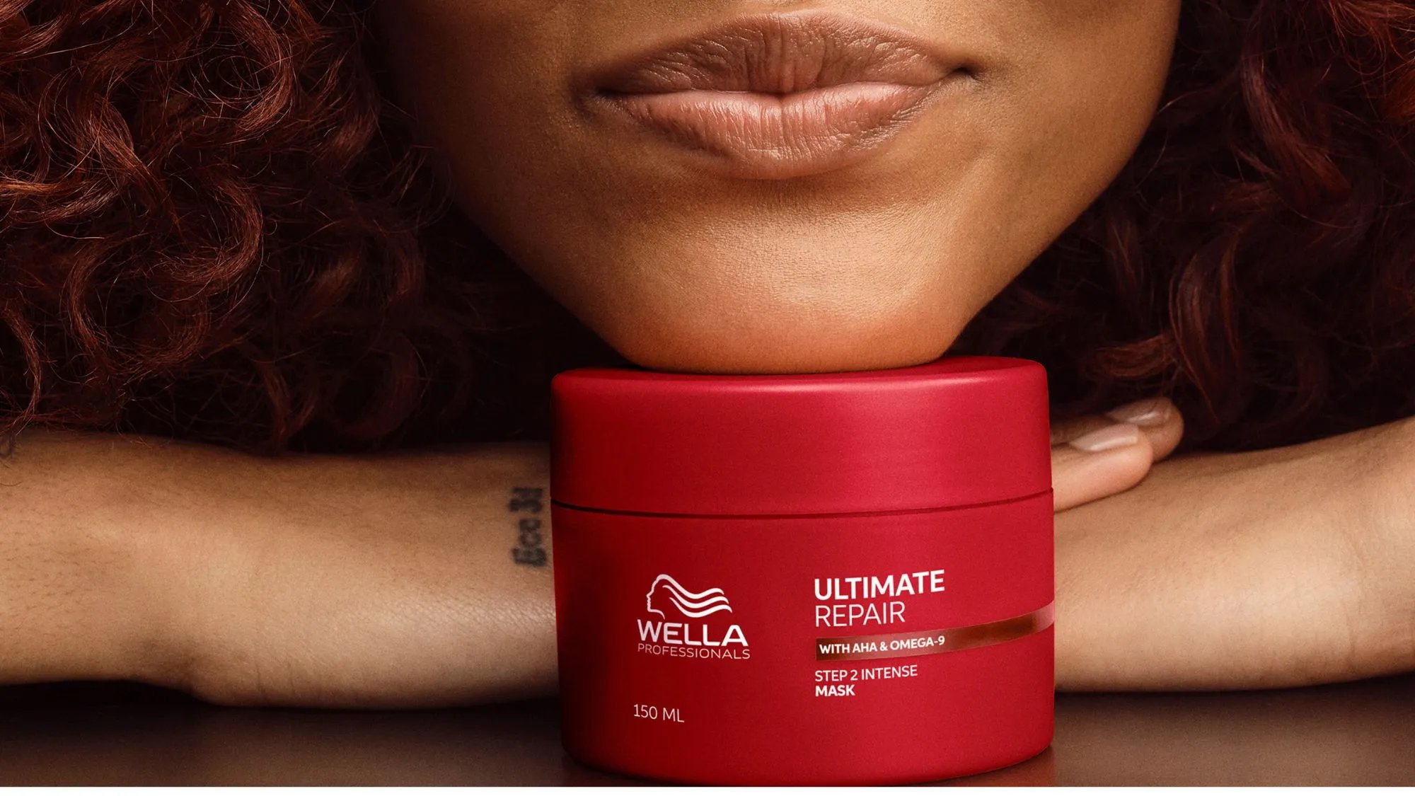 Model rests chin on jar of ULTIMATE REPAIR Mask.