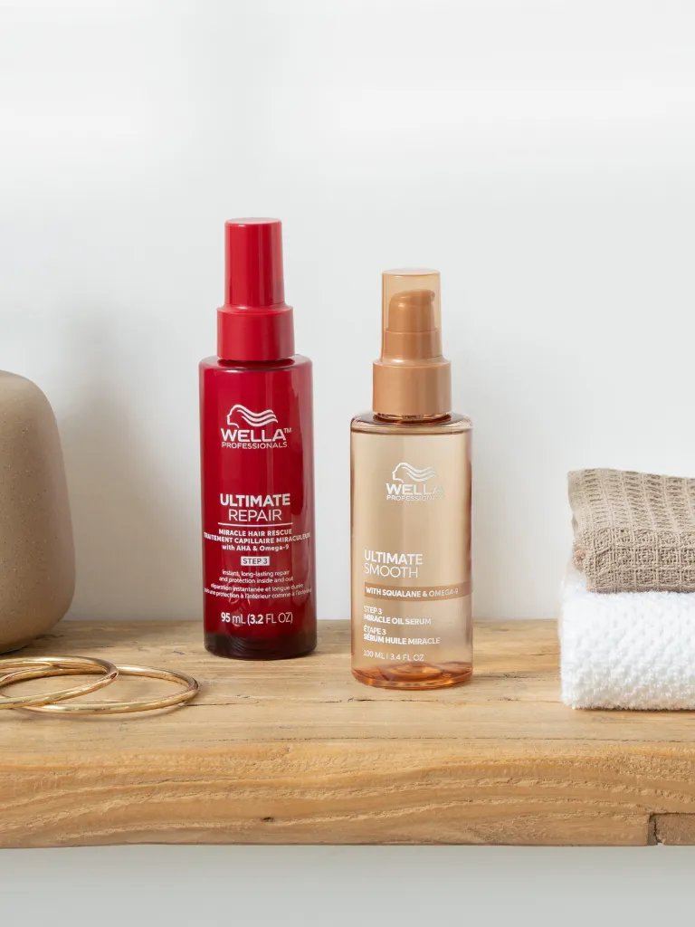 ULTIMATE REPAIR Miracle Hair Rescue and ULTIMATE SMOOTH Miracle Oil Serum on a wooden surface.