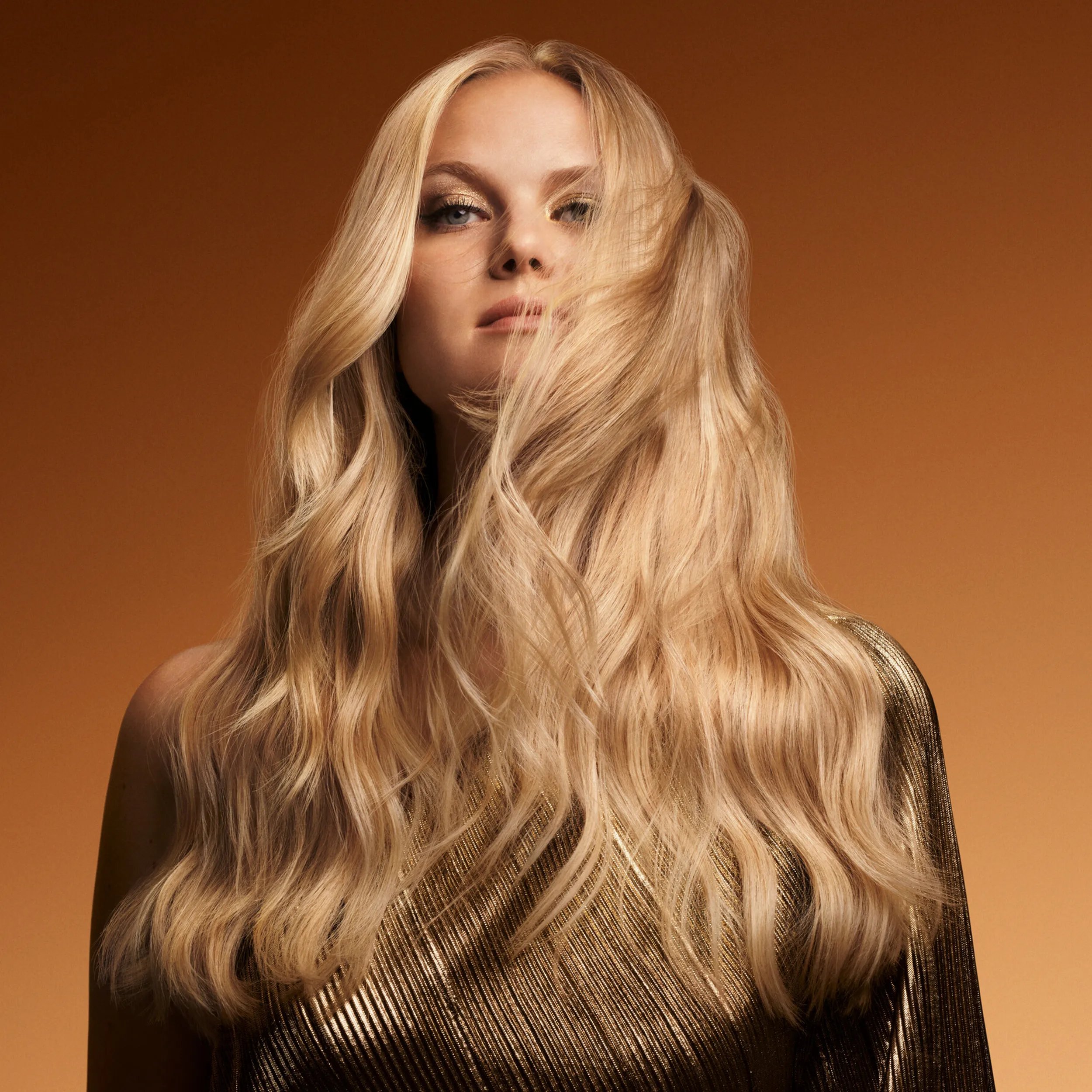 Model with long, wavy, glossy, golden blonde hair.