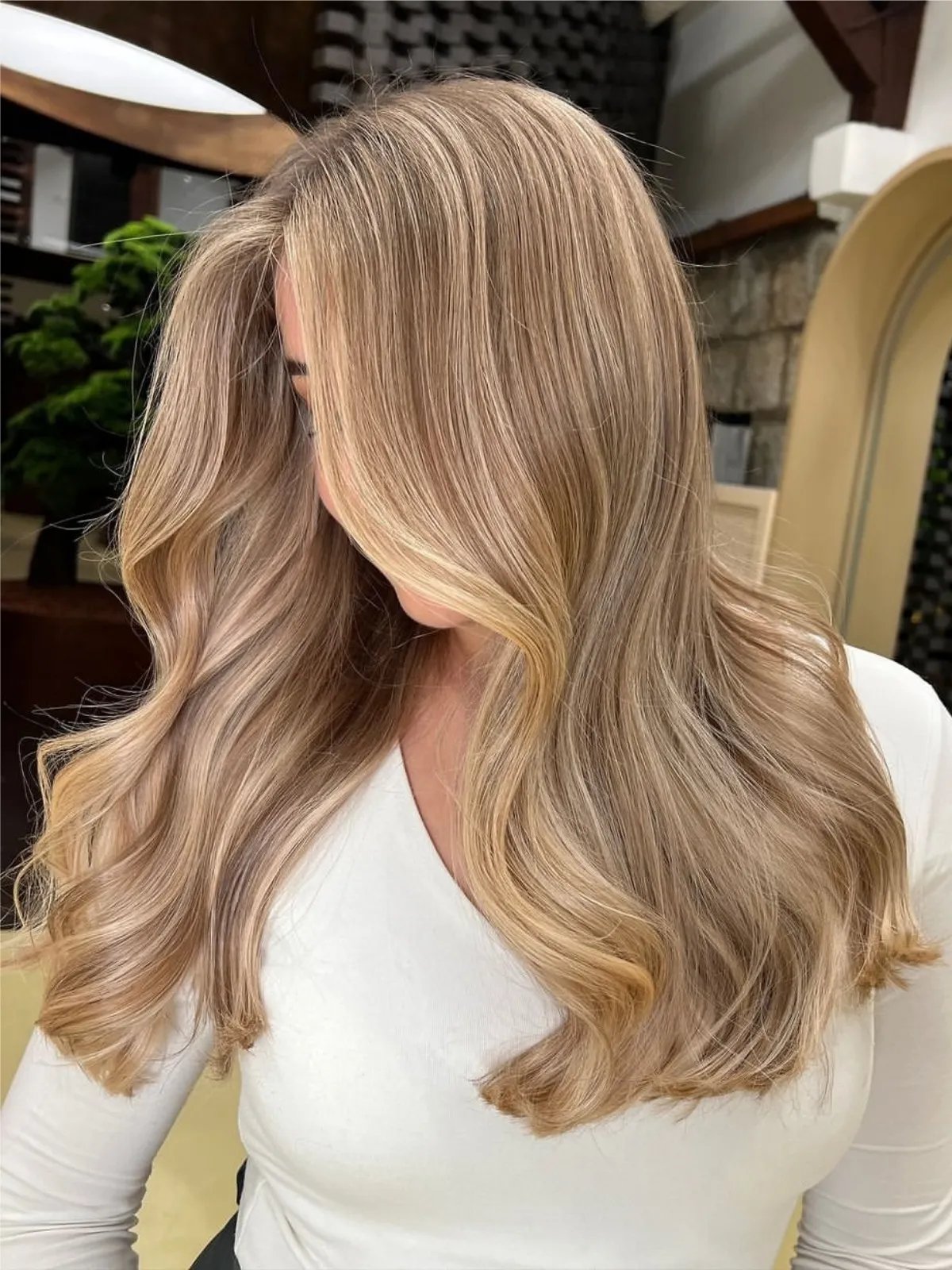 Model with dark blonde hair featuring lighter ash blonde highlights.