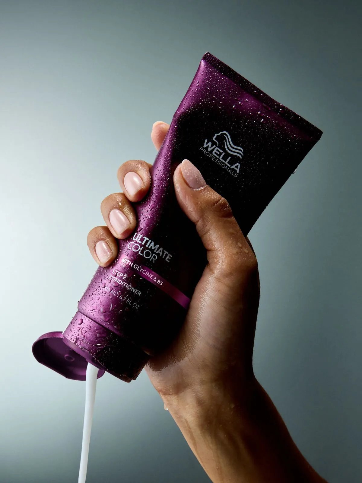 Model squeezes ULTIMATE COLOR Conditioner from the tube.