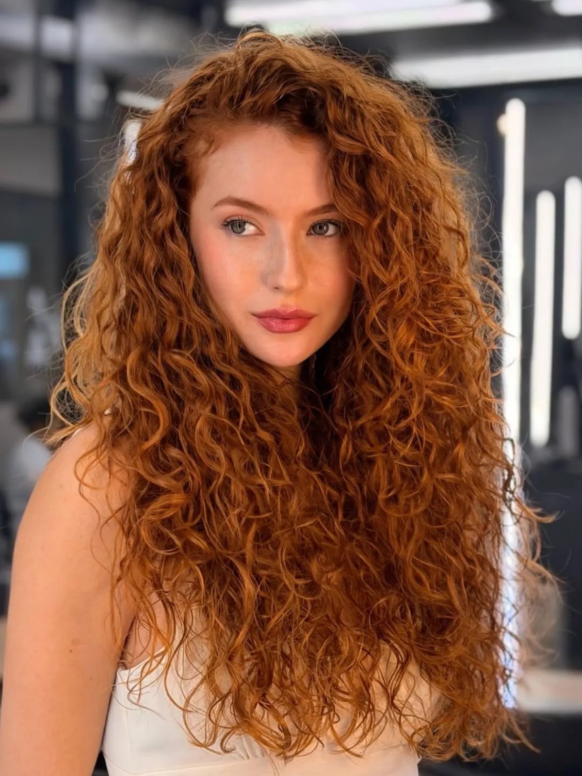 Model with long, curly, copper red hair.