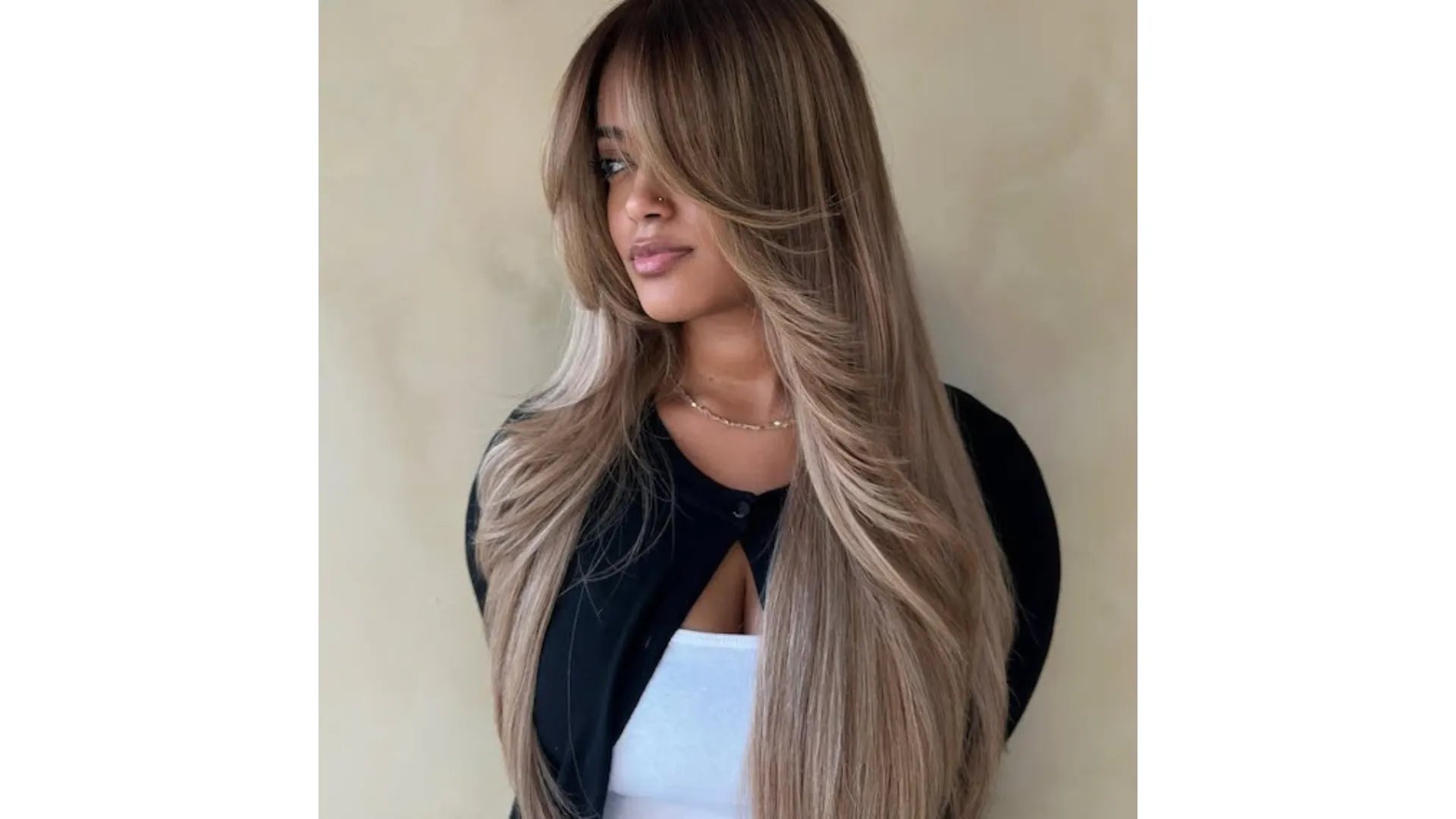Model with ultra-long, dark brown hair featuring beige blonde balayage through the mid-lengths and ends.