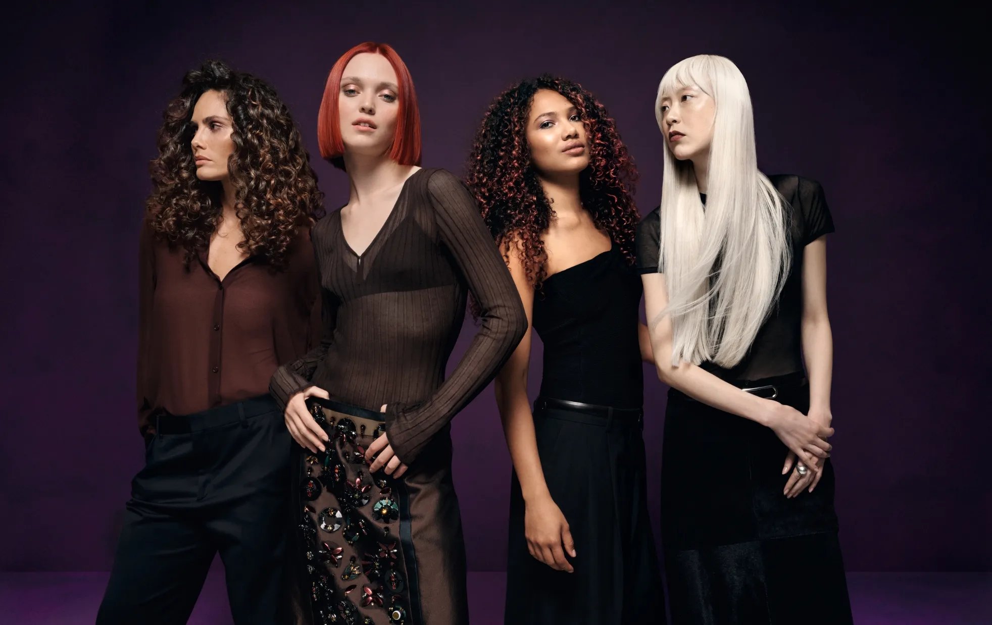 Four models: one with long, brown, curly hair, one with a cherry red bob, one with caramel curls and one with straight, platinum blonde hair.