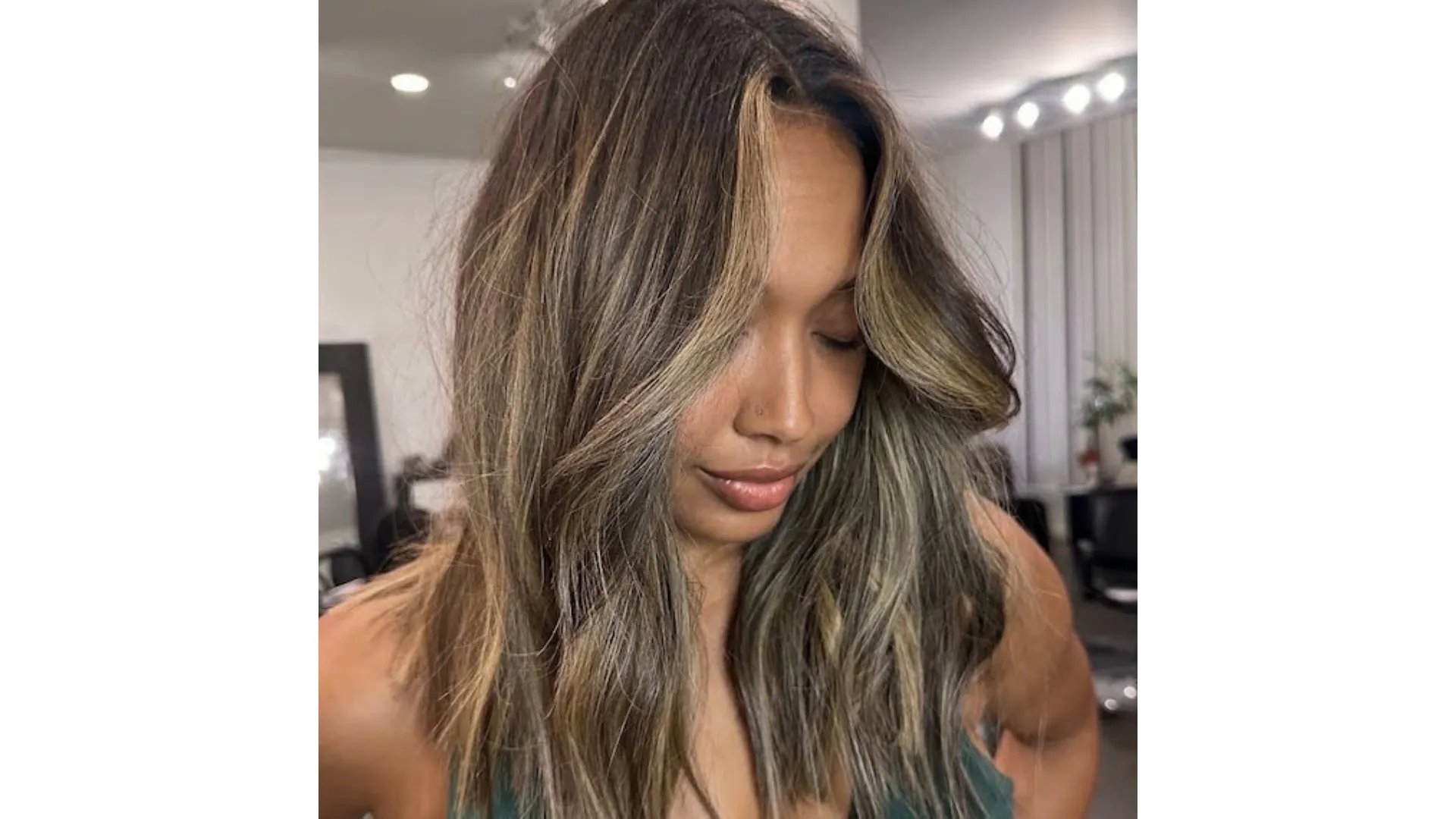 Model with loosely tousled, dark brown hair featuring caramel highlights.