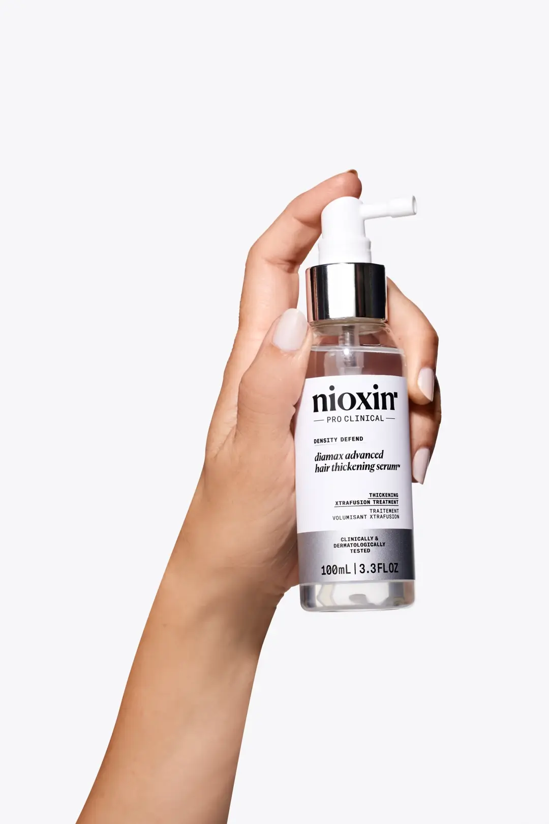 Nioxin Diamax Advanced Hair Thickening Serum in hand against white background