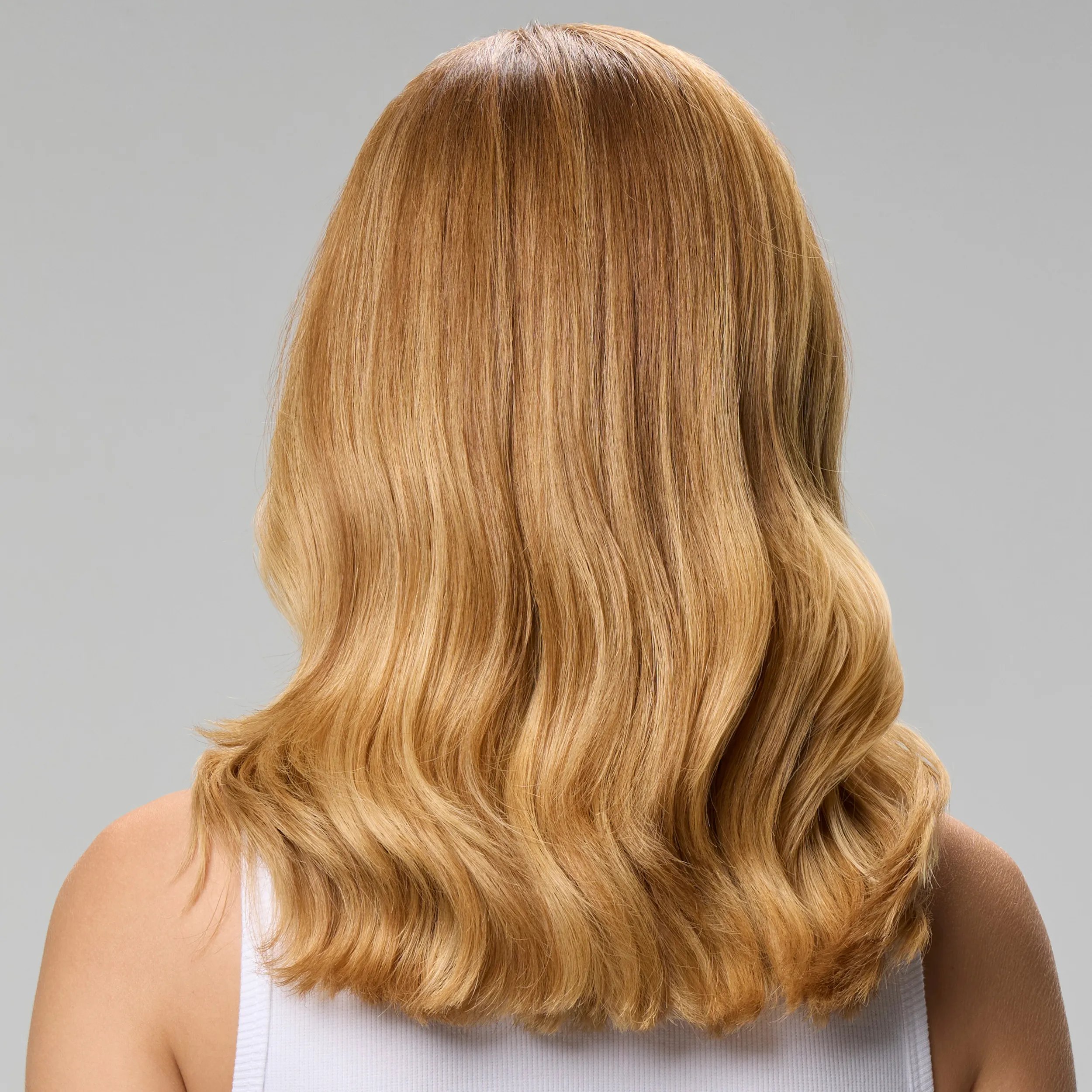 Before and after showing model’s long, dark brown, frizzy hair looking smooth and glossy after a SmoothFiller service.